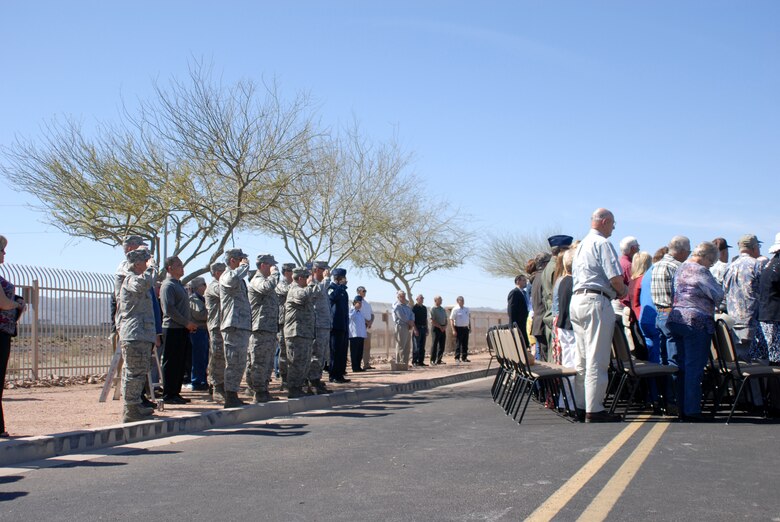 Guests stand in respect and servicemembers salute the colors during a memorial ceremony dedicating a KC-135 Stratotanker tail and plaque March 13, 2012, at the 161st Air Refueling Wing, Phoenix. The memorial ceremony marked the 30th anniversary when four 161st Air Refueling Group servicemembers lost their lives while on-duty. (Photo by Master Sgt. Robert Storm/Released)