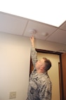 Airman 1st Class Kevin Lutker, 902nd Civil Engineer Squadron firefighter, tests a smoke alarm March 12. (US Air Force photo by Rich McFadden)