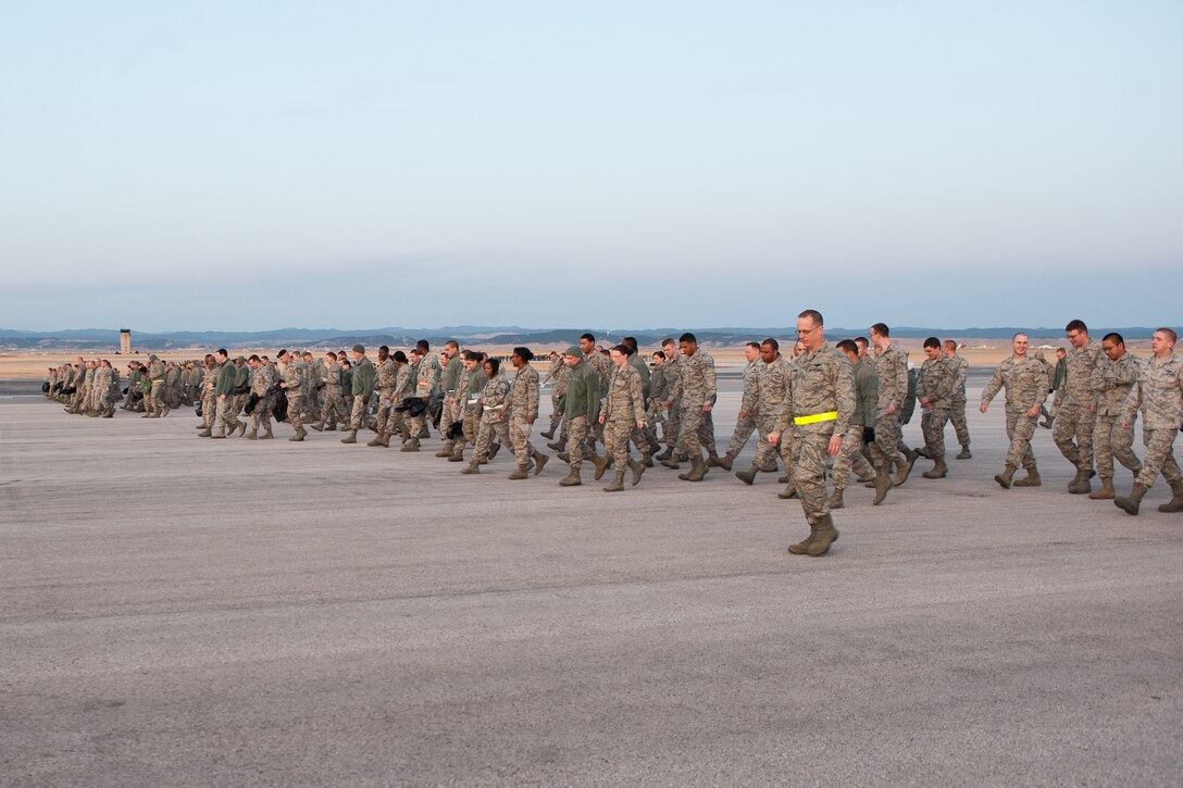 Col. Mark Weatherington, 28th Bomb Wing commander, leads Airmen down the flightline during a foreign object and debris walk on Ellsworth Air Force Base, S.D., March 12, 2012. FOD walks ensure that all rocks, screws, or any misplaced items are cleared from the runway to prevent damage to aircraft engines. (U.S. Air Force photo by Airman 1st Class Alystria Maurer/Released)