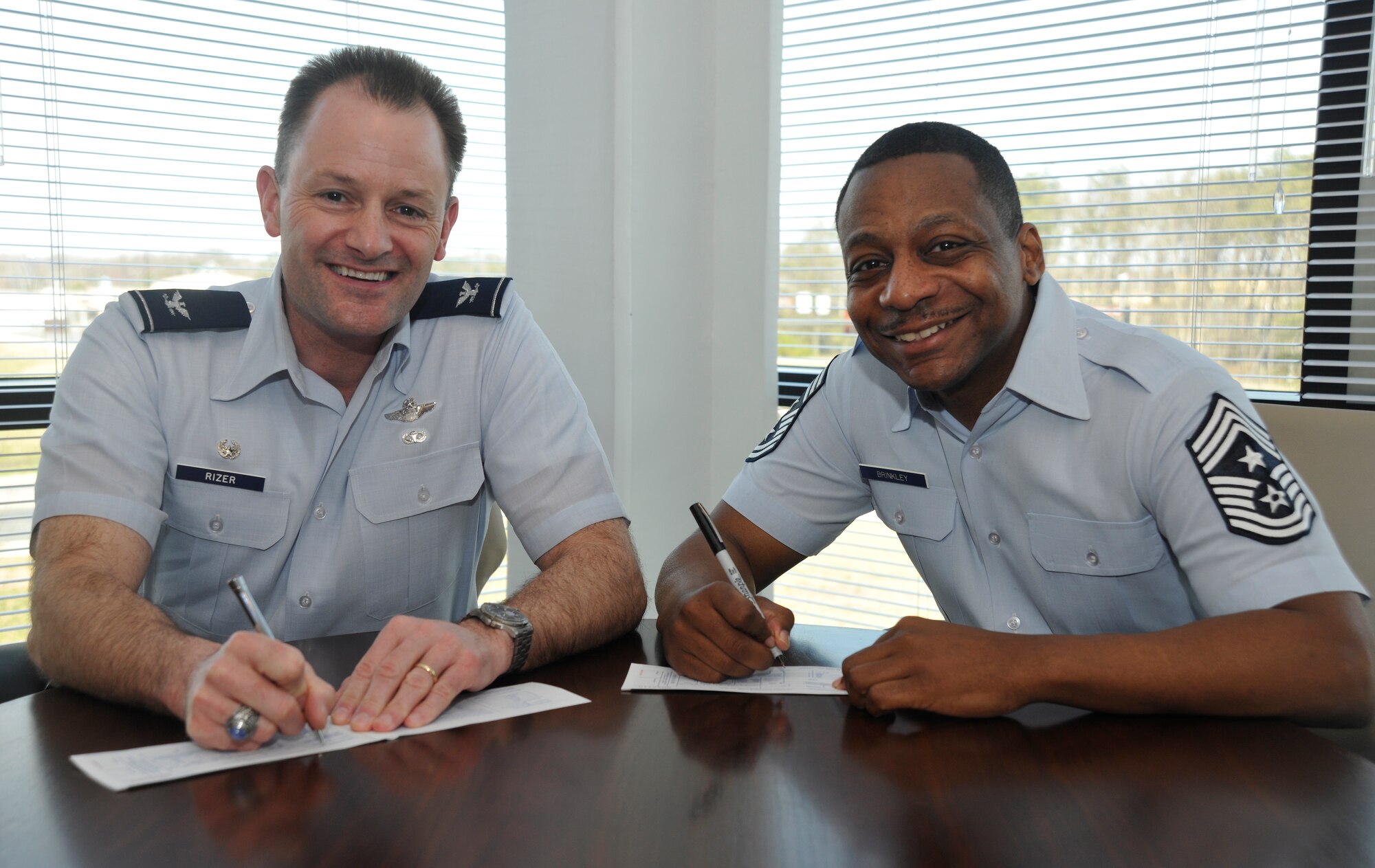 Col. Ken Rizer, 11th Wing/Joint Base Andrews commander and Chief Master Sgt. Anthony Brinkley, 11 WG/Joint Base Andrews command chief, kick off Andrews’ Air Force Assistance Fund campaign by each signing an Air Force Form 2561, the official AFAF donation form. (U.S. Air Force photo/Airman 1st Class Lindsey A. Beadle) 
