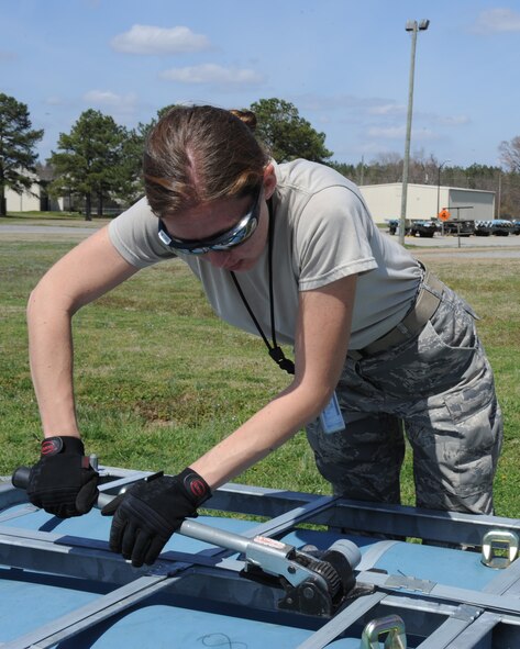 U.S. Air Force Staff Sgt. Kelly Stilson tightens a metal strap on a pallet of small-scale munitions at Seymour Johnson Air Force Base, N.C., March 12, 2012. Training munitions are placed in storage for later use on the F-15E Strike Eagle. Stilson, 4th Equipment Maintenance Squadron conventional maintenance crew chief, is from Schenectady, N.Y. (U.S. Air Force photo/Airman 1st Class John Nieves Camacho/Released)