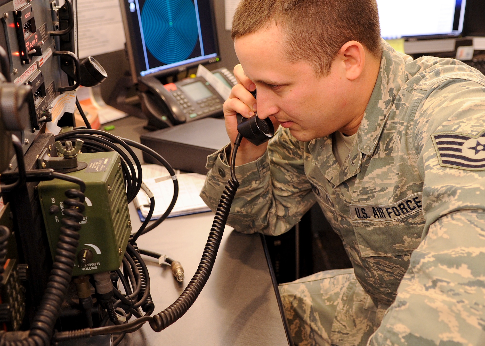 Tech. Sgt. Bruce Hedrick, a command post report NCOIC with the 180th Fighter Wing, Ohio Air National Guard, Swanton, Ohio tests a UHF/VHF/SATCOM radio. This radio allows command post personnel to speak to airborne pilots in both secure and non-secure capacities. The SATCOM capability of the radio allows world-wide communication with airborne pilots. 