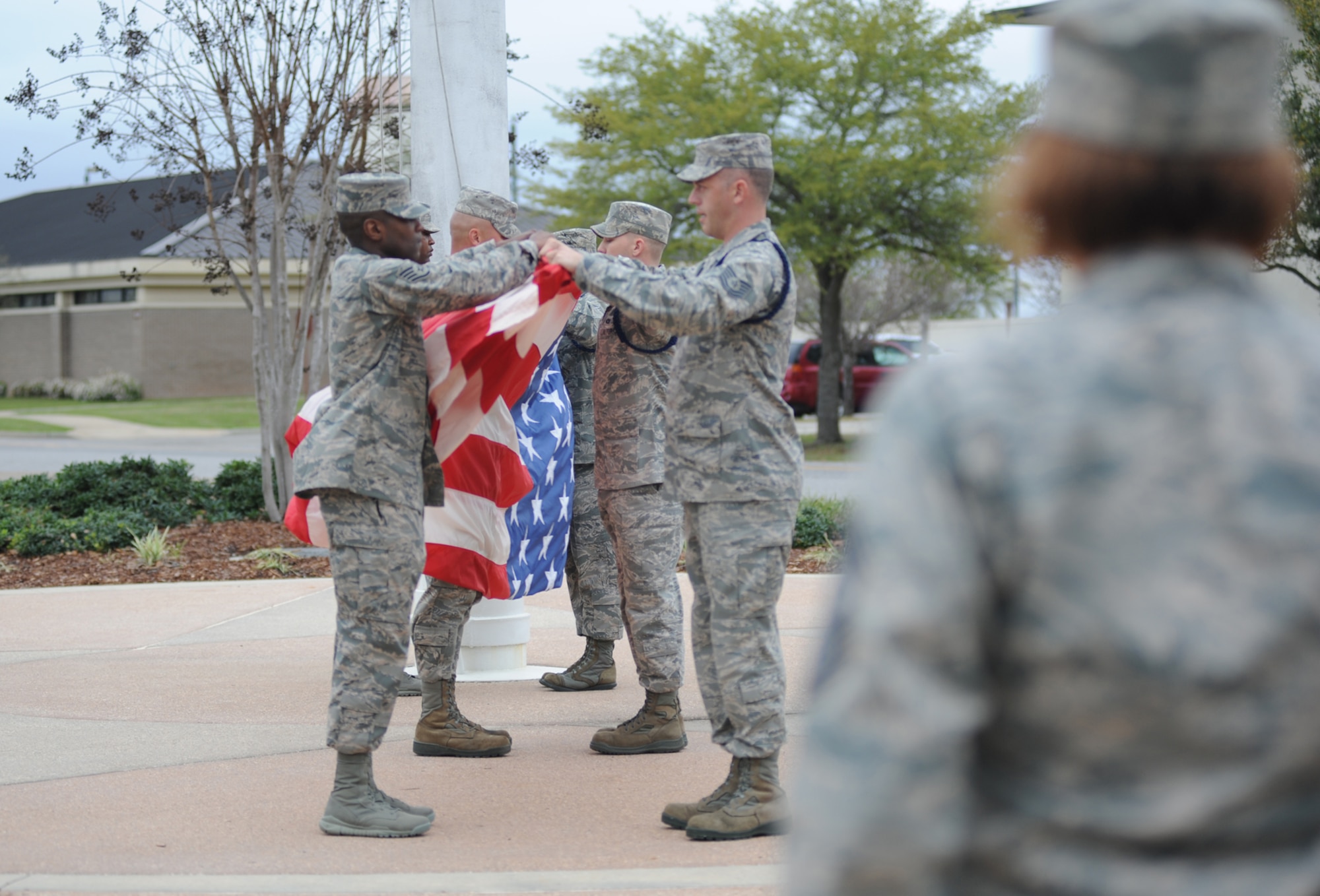 Military Training Leaders serve as the flag security detail and perform a flag folding ceremony during the 81st Training Wing retreat ceremony March 9, 2012, Keesler Air Force Base, Miss.  The Keesler Drum and Bugle Corps played the Nation Anthem and America the Beautiful.  (U.S. Air Force photo by Kemberly Groue)