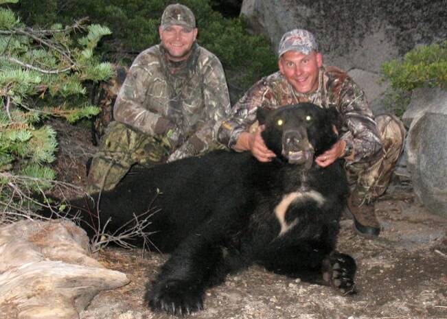 (Right) Master Sgt. Chad Hepner, 9th Medical Group first sergeant, and (left) Master Sgt. Nathan Schmidt, 9th Security Forces Squadron first sergeant, pose with a black bear Hepner harvested in California during the 2011 bear season. Hepner hunts so much that his family hasn't bought a cut of meat from a grocery store in 19 years. (U.S. Air Force courtesy photo)
