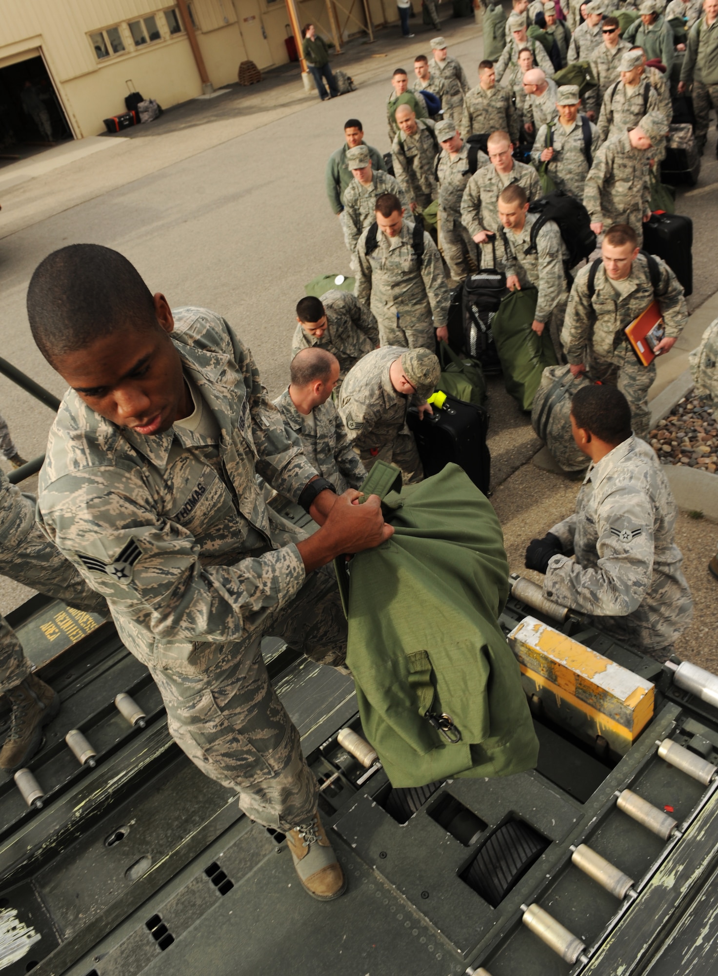 U.S. Air Force Senior Airman Travis Thomas, 366th Aerospace Medical Squadron bio-environmental flight, assists in baggage detail before personnel leave for a deployment March 12, 2012, at Mountain Home Air Force Base, Idaho.  Approximately 200 Airmen from across the 366th Fighter Wing deployed to Southwest Asia in support of Operation Enduring Freedom. (U.S. Air Force photo/ Senior Airman Debbie Lockhart)