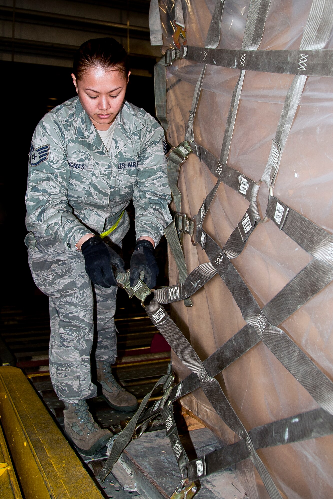 JOINT BASE MCGUIRE-DIX-LAKEHURST, N.J. – Staff Sgt. Kristine Thomas, 88th Aerial Port Squadron, tightens the straps on a cargo net at the aerial port warehouse here March 11, 2012. In preparation for the 514th Air Mobility Wing’s operational readiness inspection, Thomas and other aerial porters taught a pallet buildup class for other Airmen of the Freedom Wing. (U.S. Air Force photo by Shawn J. Jones)