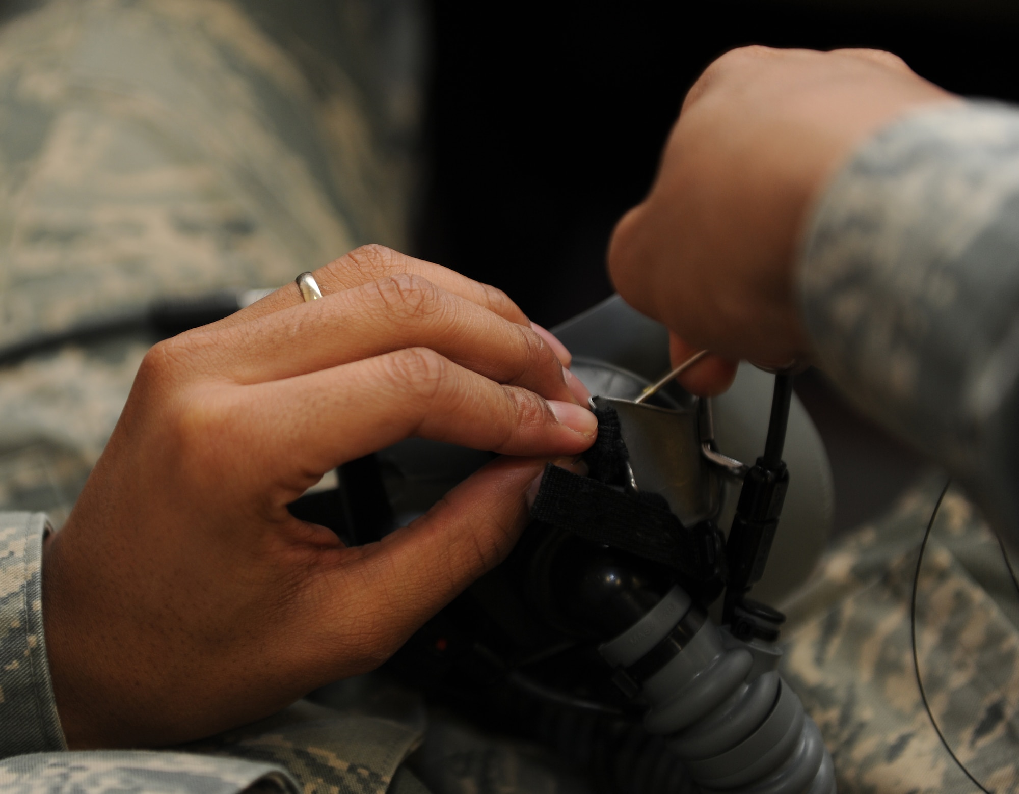 KONYA, Turkey -- Airman 1st Class Adryan Elszy, aircrew flight equipment, tacks the adjustment straps of a mask down to ensure the stay in position and the mask maintains a good seal during flight, March 12. Elszy was participating in Exercise Anatolian Falcon 2012, bilateral training exercise with the U.S. and Turkish air forces. (U.S. Air Force photo/Staff Sgt. Benjamin Wilson)