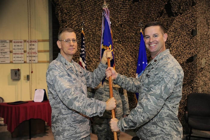 Colonel Philip Greco passes the 376th Expeditionary Aircraft Maintenance Squadron guidon to Maj. Ryan White at a change of command ceremony at the Transit Center at Manas, Kyrgyzstan March 5. Greco is the 376th Expeditionary Maintenance Group commander deployed from Gunter Air Force Base, Ala. White is deployed from the 437th Aircraft Maintenance Squadron, 437th Airlift Wing, Joint Base Charleston – Air Base.(U.S. Air Force photo courtesy 376th Expeditionary Aircraft Maintenance Squadron)