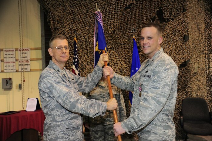 Major Jeff Darden relinquishes command of the 376th Expeditionary Aircraft Maintenance Squadron by passing the squadron guidon to Col. Philip Greco at the Transit Center at Manas, Kyrgyzstan March 5. Greco is the 376th Expeditionary Maintenance Group commander deployed from Gunter Air Force Base, Ala. Darden is deployed from the 437th Maintenance Squadron, 437th Airlift Wing at Joint Base Charleston – Air Base. (U.S. Air Force photo courtesy of the 376th Expeditionary Aircraft Maintenance Squadron