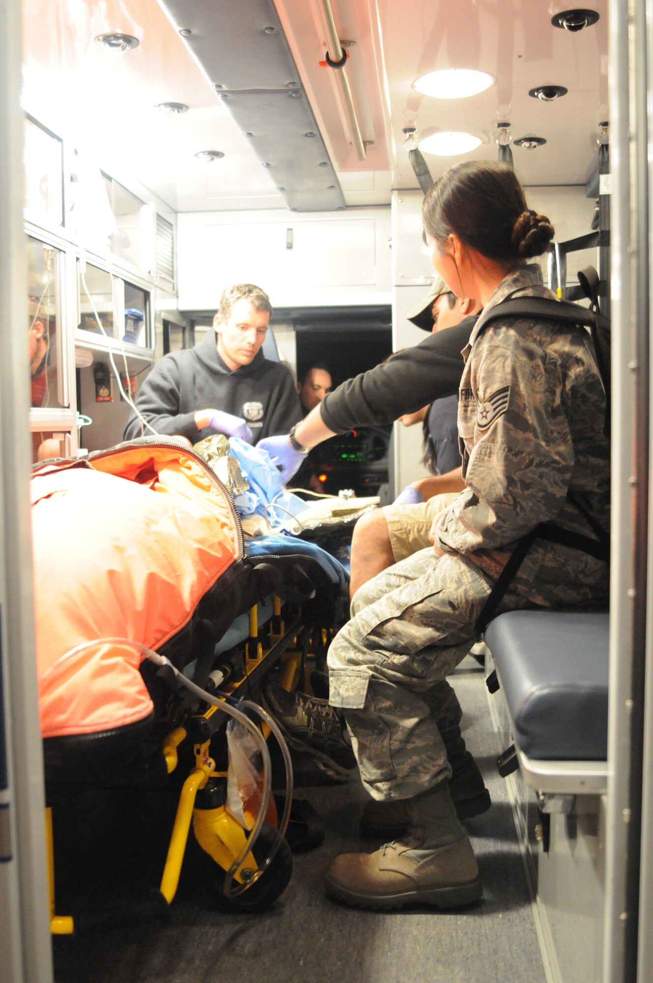 Staff Sgt. Hong Zhou, an Airman from the 129th Logistics Readiness Squadron, translates Chinese for pararescuemen as they transfer an injured fisherman to San Diego area paramedics at Marine Corps Air Station Miramar, Calif., March 12, 2012. 129th RQW Airmen conducted a long-range over-water rescue mission 700 miles off the coast of Mexico March 10-12 to save two fishermen who were burned in a diesel fire onboard the Chinese fishing vessel, Fu Yuan Yu #871. (Air National Guard Photo by Master Sgt. Julie Avey)