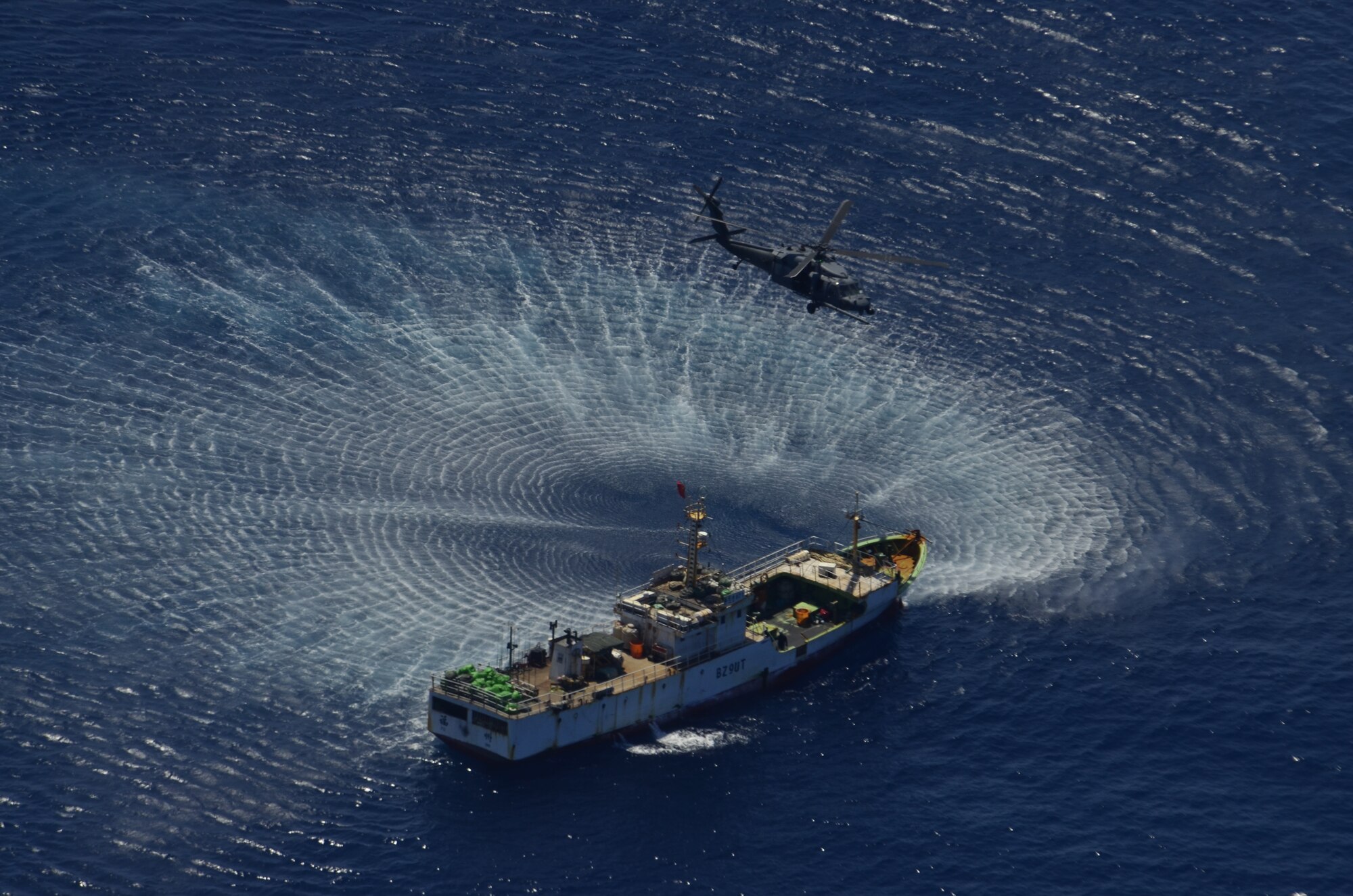 An HH-60G Pave Hawk rescue helicopter from the 129th Rescue Wing hovers over the Chinese fishing vessel Fu Yuan Yu #871, March 12, 2012. Guardian Angel Pararescuemen from the wing rescued two fishermen who were burned in a diesel fire onboard the vessel more than 700 miles off the coast of Acapulco, Mexico. (Air National Guard photo by Airman 1st Class John Pharr)