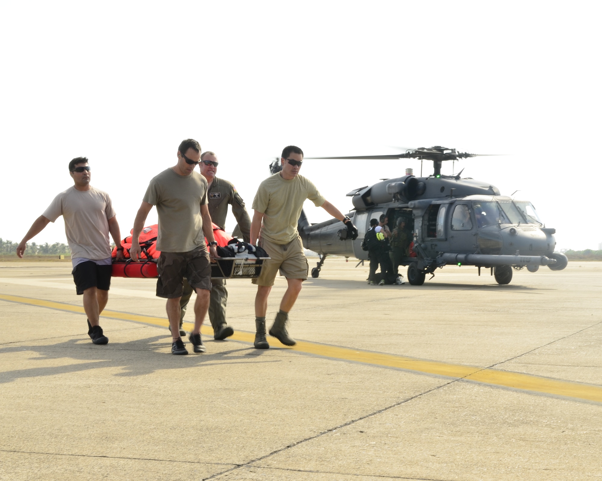 Guardian Angel Pararescuemen from the 129th Rescue Wing carry an injured fisherman off an HH-60G Pave Hawk rescue helicopter, Mar. 12, 2012.  The injured fisherman was flown to San Diego, Calif. for further medical treatment.  MC-130P Combat Shadow aircraft, HH-60G Pave Hawk rescue helicopters and Guardian Angel Pararescuemen from the wing were used to conduct a long-range over-water mission to rescue two fishermen who were burned in a diesel fire onboard the Chinese fishing vessel Fu Yuan Yu #871.  (Air National Guard photo by Airman 1st Class John Pharr)