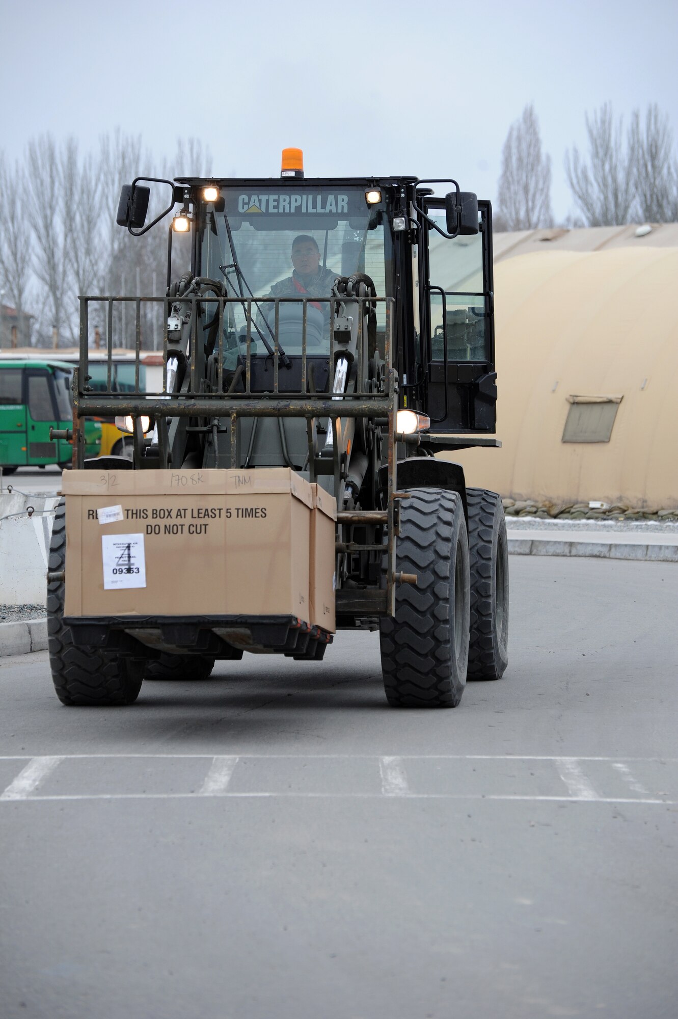 Master Sgt. Paul Ikeda, 376th Expeditionary Logistics Readiness Squadron theater express manager, moves two boxes of mail to the post office at the Transit Center at Manas, Kyrgyzstan, March 11, 2012. The Transit Center received more than 10,000 pounds of mail March 11; it was one of the largest shipments ever delivered here. Ikeda is deployed to the Transit Center from Travis Air Force Base, Calif., and his hometown is Leandro, Calif. (U.S. Air Force photo/Master Sgt. Tracy L. DeMarco) 
