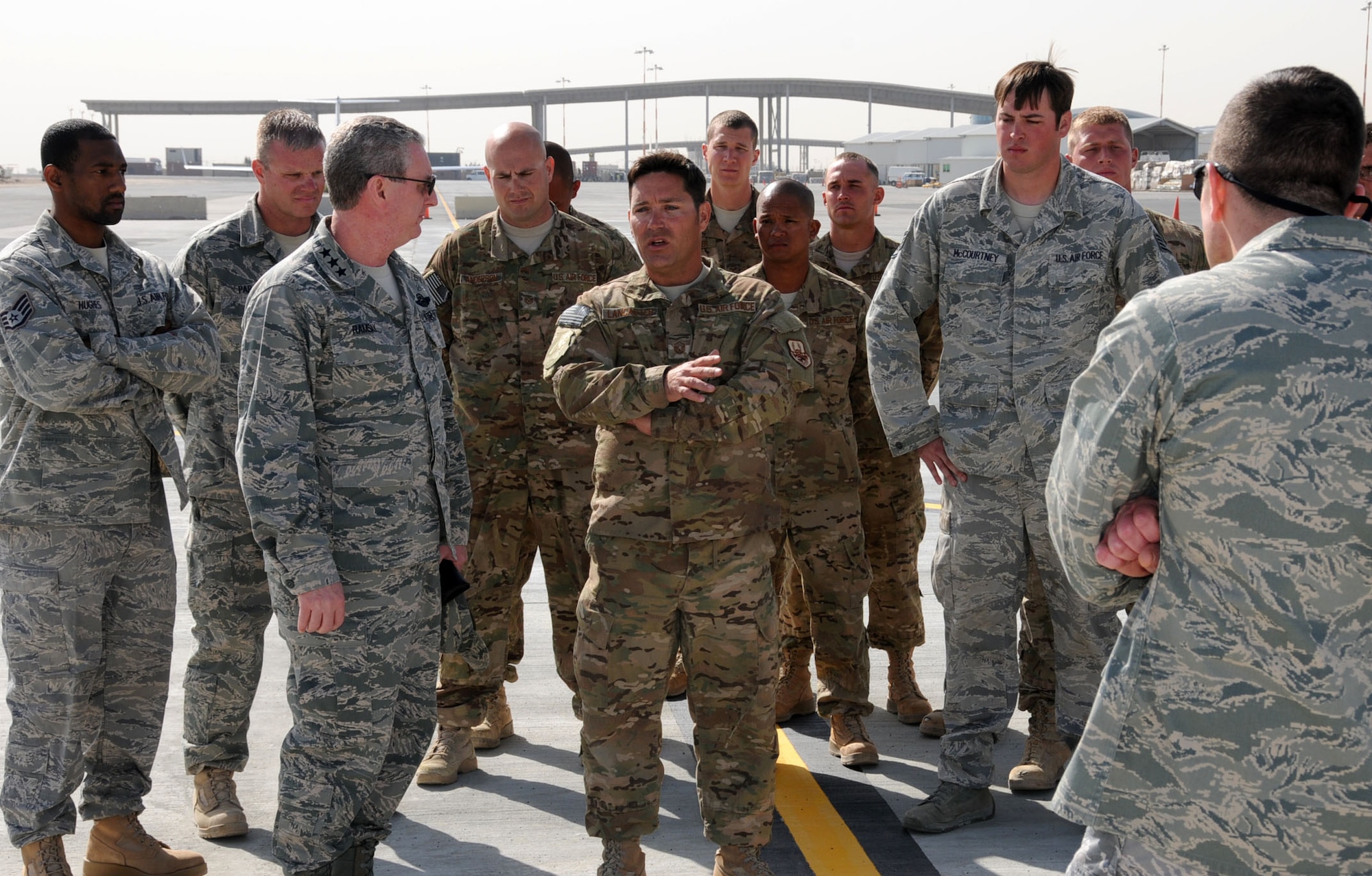 U.S. Air Force Lt. Gen. Mark Ramsay, commander of the 18th Air Force, visits with Master Sgt. James Lancaster and members of the 557th Expeditionary RED HORSE Squadron at an undisclosed location in Southwest Asia, March 8, 2012. Ramsay congratulated them on the completion of a $3.4 million ramp repair project - the largest project during their rotation - 39 days ahead of schedule.  RED HORSE placed more than 8,000 cubic meters of concrete and 47,000 tons of asphalt to repair major defects that kept some aircraft from landing there. Lancaster, a Wilmington, N.C., native, is deployed from the 820th RED HORSE Squadron, Nellis Air Force Base, Nev. (U.S. Air Force photo by Staff Sgt. James Lieth)