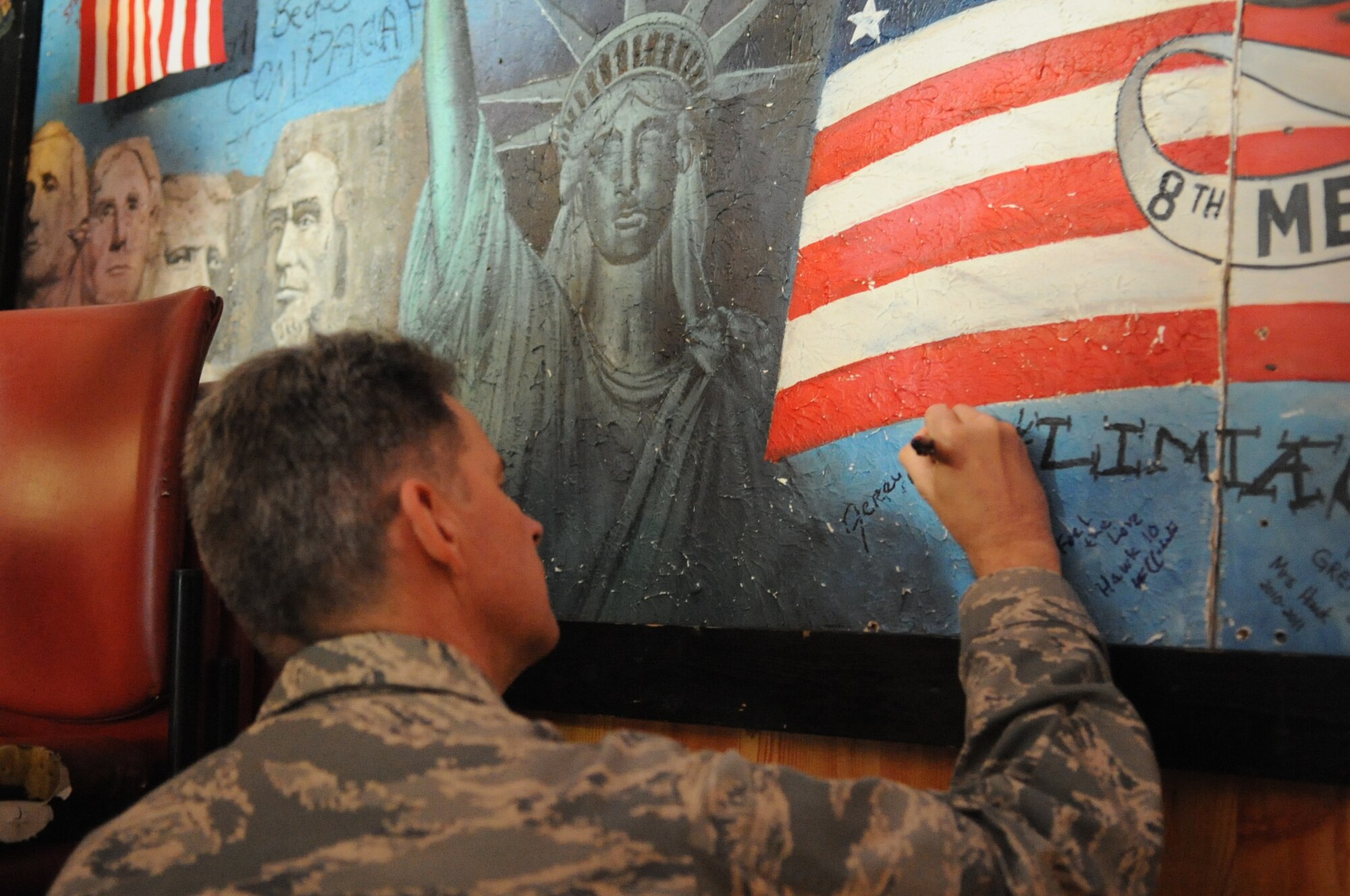 Maj. Gen. Gerard Caron, assistant surgeon general for dental services, signs the “VIP Wall” after touring the 8th Medical Group at Kunsan Air Base, Republic of Korea, March 9, 2012. Other people who have signed the wall include Wolf 1, retired Brig. Gen. Robin Olds, and retired Chief Master Sgt. of the Air Force Rodney McKinley. (U.S. Air Force photo by Senior Airman Brigitte N. Brantley/Released)