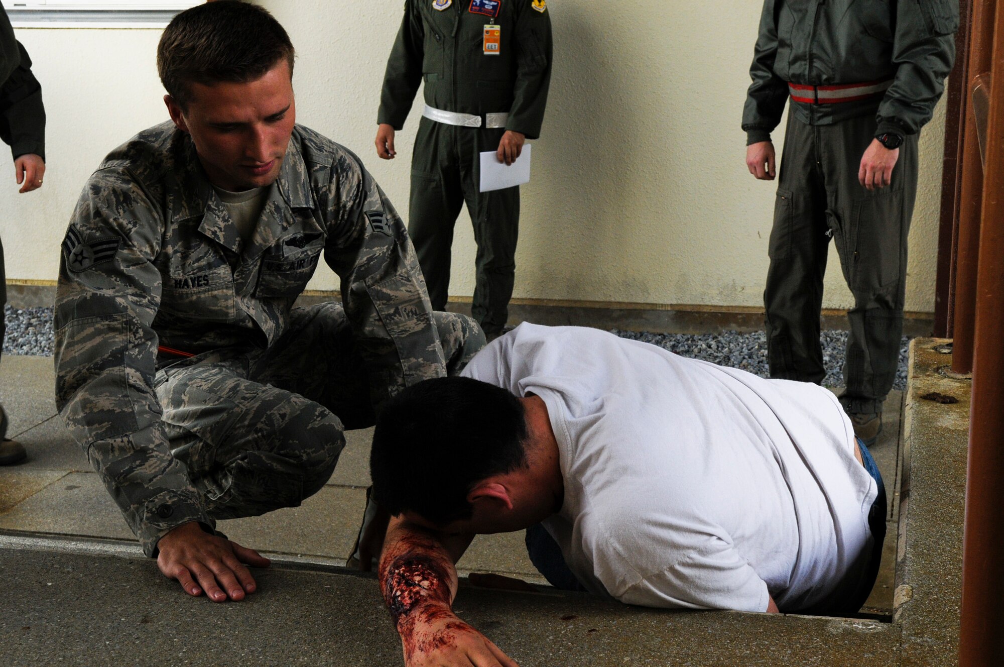 U.S. Air Force Senior Airman Harrison Hayes, a 961st Airborne Air Control Squadron communications technician, rushes to the aid of a simulated victim with an arm laceration during local operational readiness exercise Beverly High 12-3 on Kadena Air Base, Japan, March 12, 2012. LOREs give Airmen the opportunity to practice readiness skills to prepare for real world contingencies. (U.S. Air Force photo by Airman 1st Class Tara A. Williamson/Released)