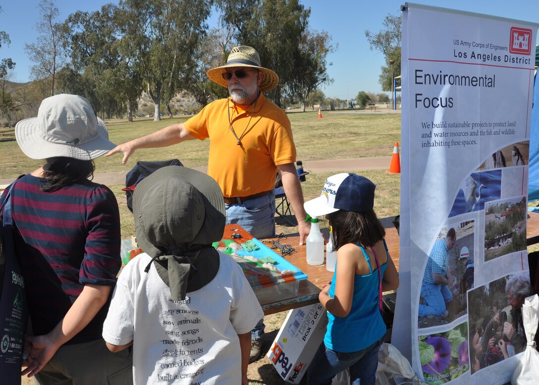 GOODYEAR, Ariz. - Vic Bartkus, a U.S. Army Corps of Engineers Los Angeles District team member, speaks with a family Mar. 10 about the District's involvement in ecosystem restoration at the annual Tres Rios Nature and Earth Festival. The festival draws in government agencies and organizations from across Arizona interested in promoting awareness of the history and habitat in the Phoenix area. 
