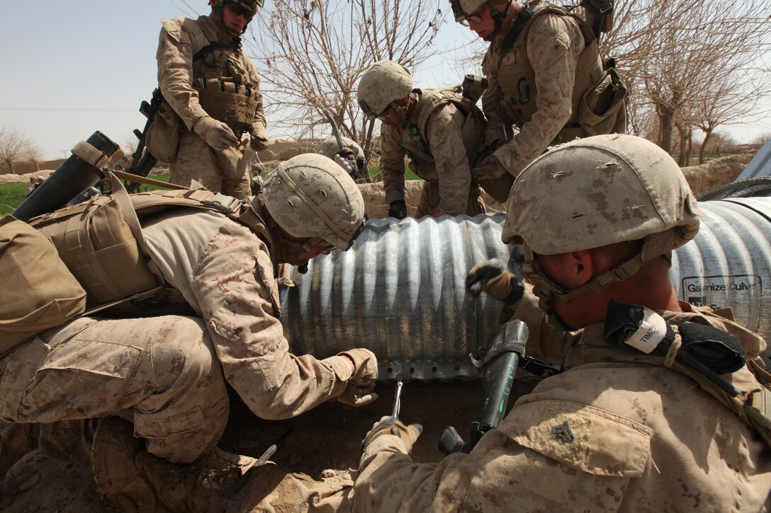 Marines with Engineer Support Company Detachment, 9th Engineer Support Battalion, 1st Marine Logistics Group (Forward) place nuts and bolts on a culvert, March 14. The culvert is a tunnel built under a bridge to allow water to pass.
