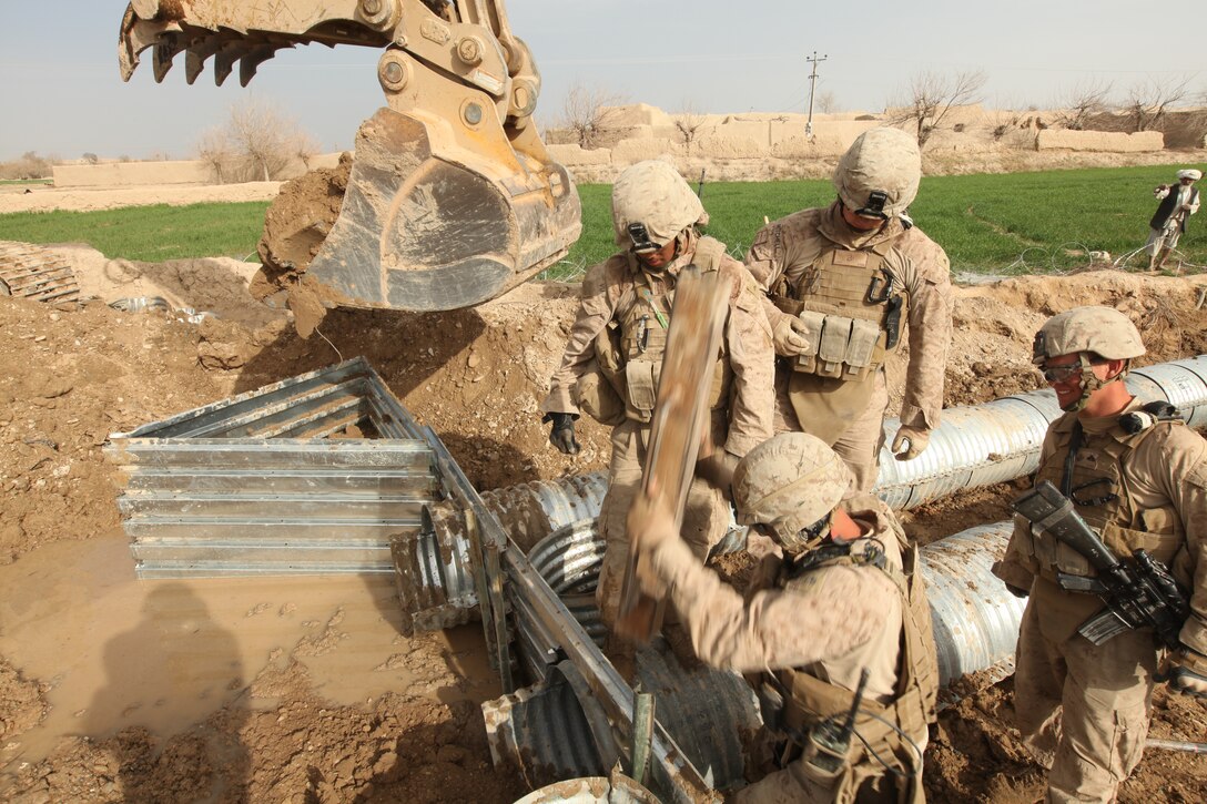 Sgt. Dale Steinecke Jr., an engineer equipment mechanic with Engineer Support Company Detachment, 9th Engineer Support Battalion, 1st Marine Logistics Group (Forward), slams home a pole-driver on an engineer stake, March 14. The Marines took part in a 2-day road reconstruction project which called for a bridge and culvert system to be replaced.