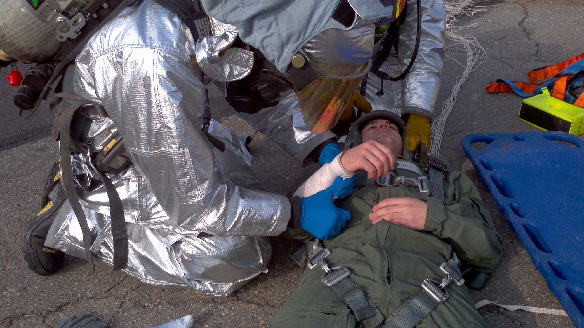 Firefighters assist the pilot of a simulated aircraft accident on Kunsan Air Base, Republic of Korea, March 14, 2012. Airmen were tested on how they overcame obstacles to assist victims and provide essential care. (U.S. Air Force photo by Senior Airman Jessica Hines/Released)