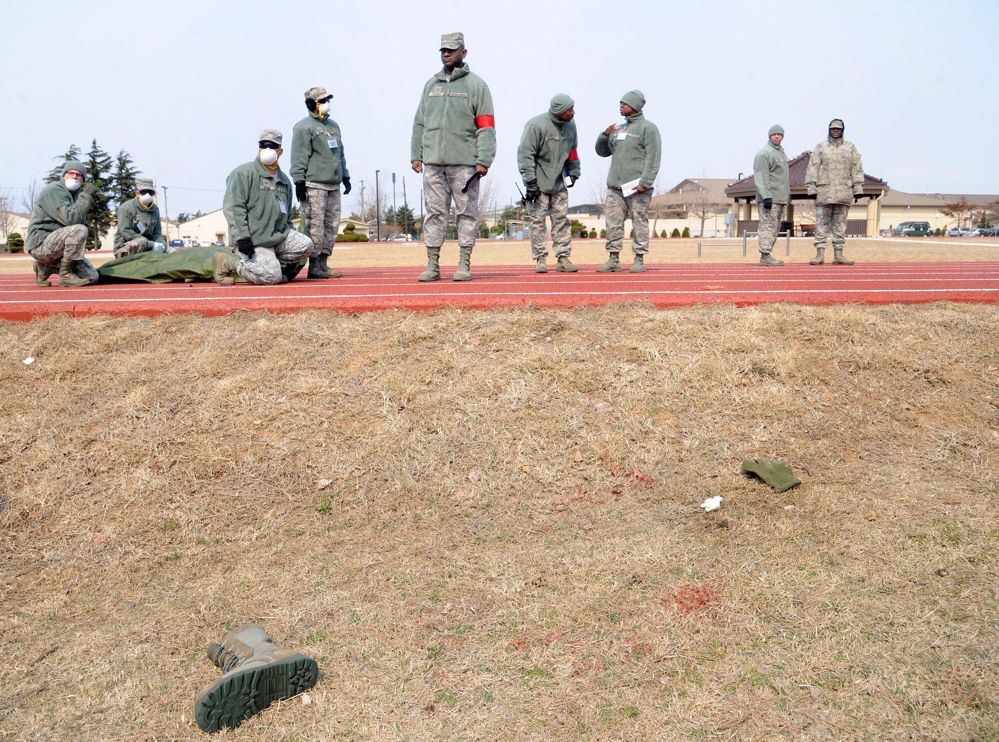 Airmen and inspectors watch and wait as first responders finish helping exercise victims during an emergency management exercise on Kunsan Air Base, Republic of Korea, March 14, 2012. The base will soon be inspected by higher headquarters during a combined unit inspection in April. (U.S. Air Force photo by Staff Sgt. Rasheen Douglas/Released)