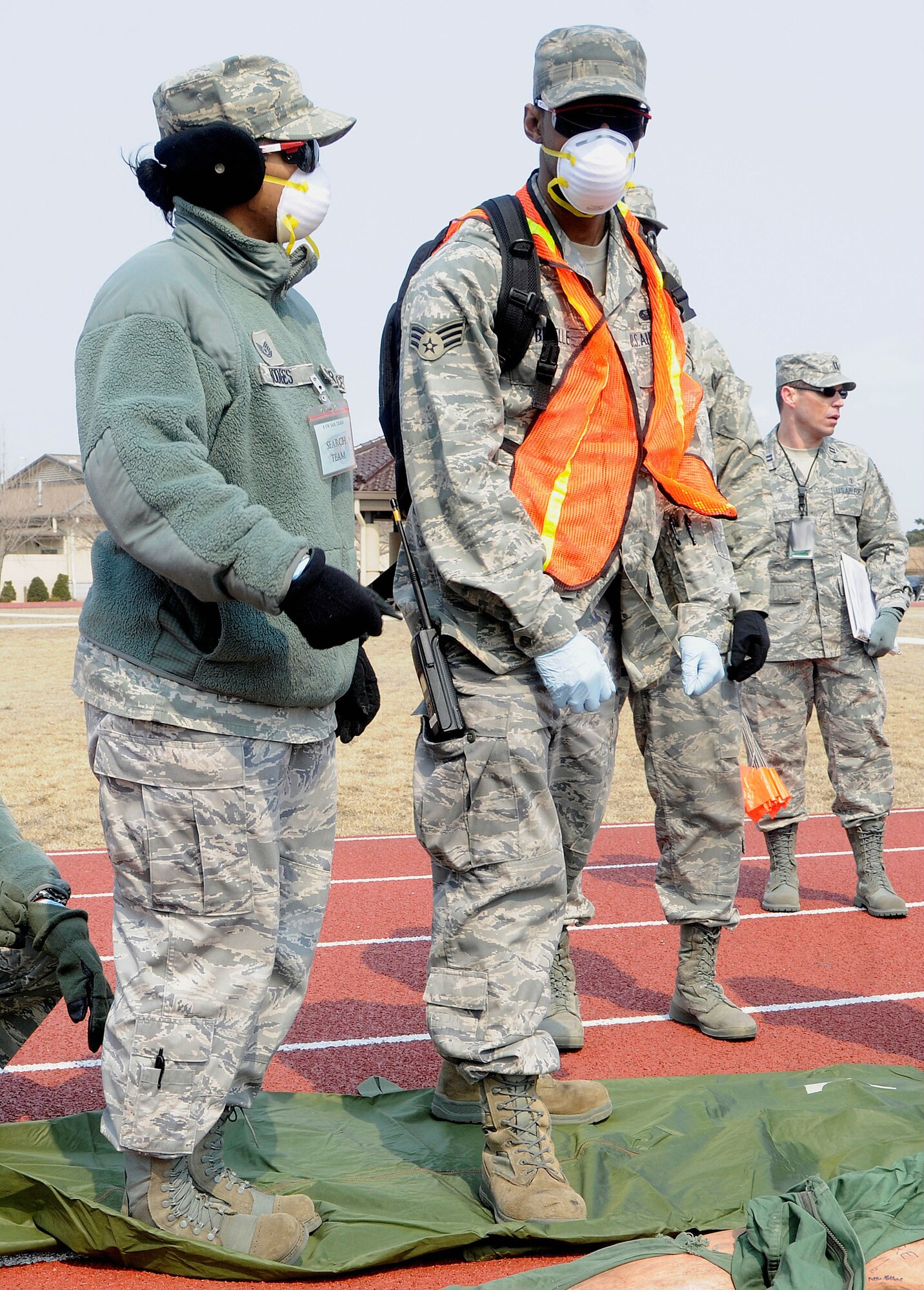 Airmen wait as emergency responders finish helping exercise victims during an emergency management exercise on Kunsan Air Base, Republic of Korea, March 14, 2012. The exercise kicked off at approximately 9 a.m., with loud explosions near the 8th Fighter Wing headquarters building. (U.S. Air Force photo by Staff Sgt. Rasheen Douglas/Released)