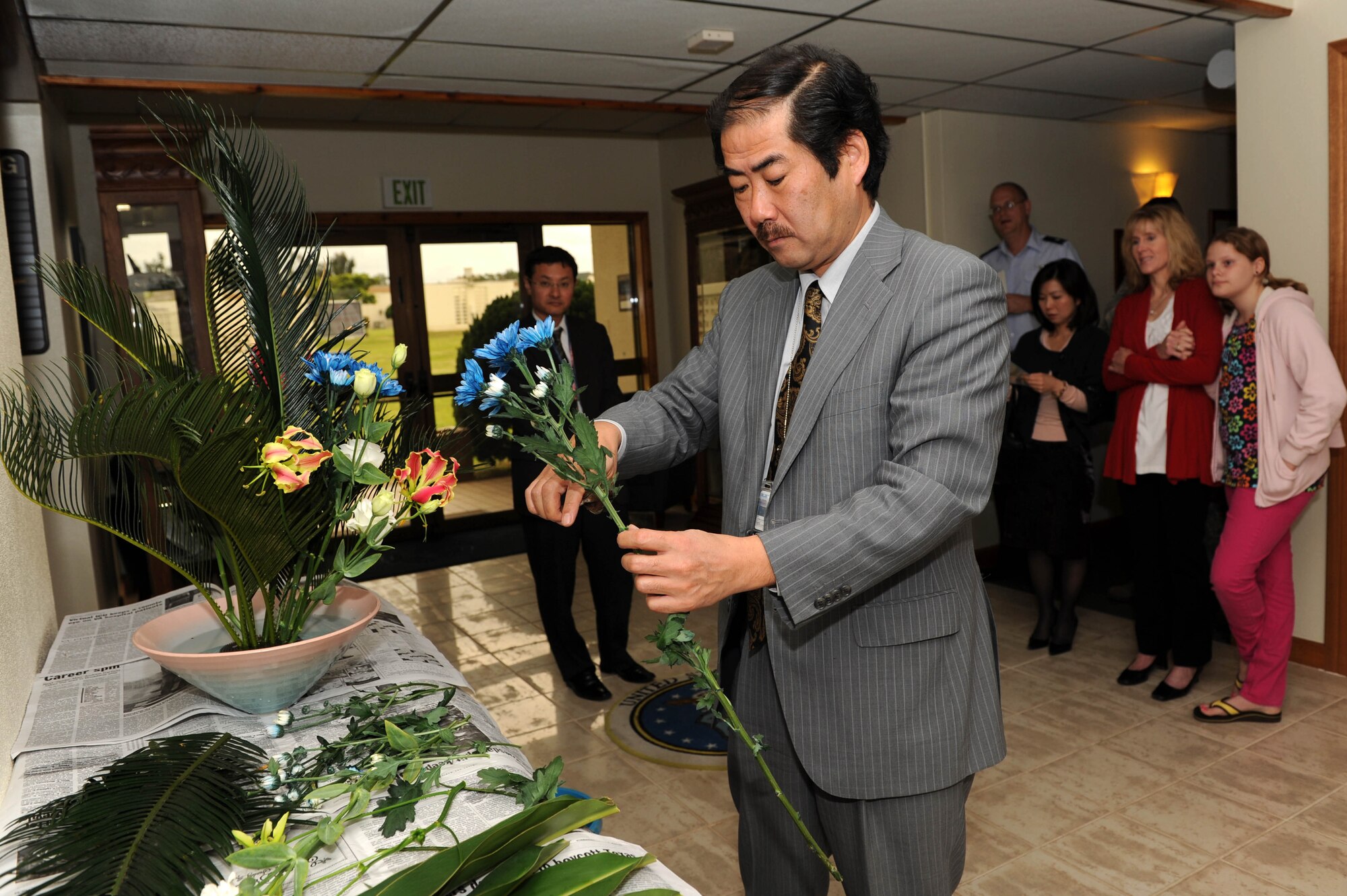 Mr. Kingo Ikeda, Okinawa Defense Bureau Public Affairs chief, creates an ikebana Ikenobo flower arrangement at the 18th Wing headquarters during his visit to Kadena Air Base, Japan, March 14, 2012. Military members and families were able to enjoy seeing the “Wing of Peace” being created before them. (U.S. Air Force photo by Junko Kinjo/Released)