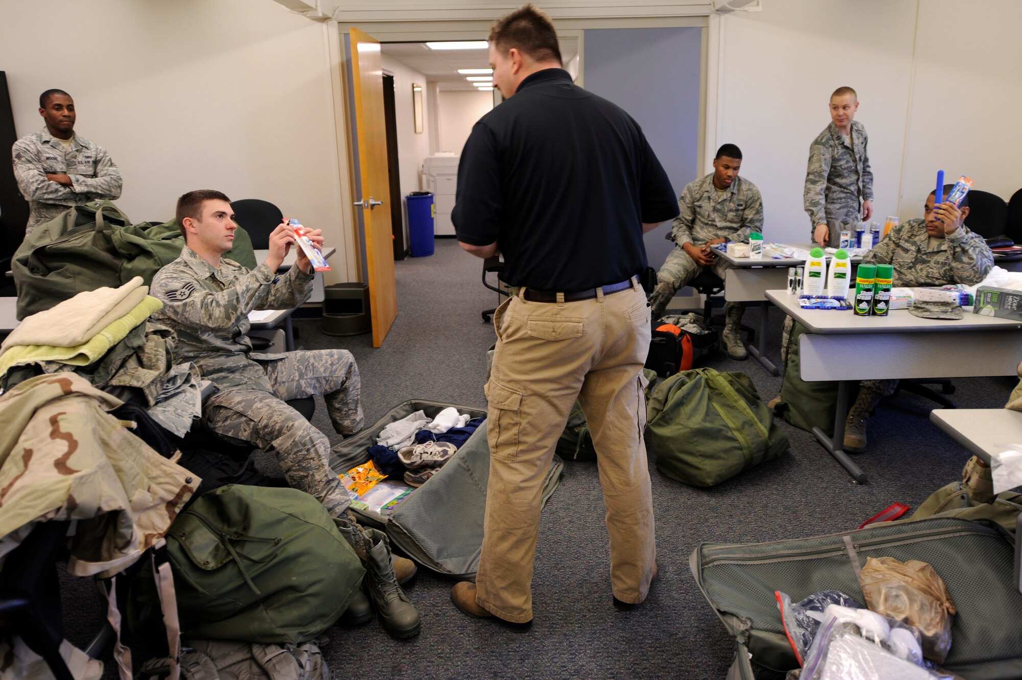 VANDENBERG AIR FORCE BASE, Calif. -- Matthew Hansen, 30th Comptroller Squadron and Wing Staff Agency unit deployment manager, assists deployers preparation during the Northstar exercise bag drag here Thursday, March 8, 2012. A mobility bag consists of items essential for a deployer to have when tasked to deploy at a moments notice. (U.S. Air Force photo/Staff Sgt. Andrew Satran) 

 
 