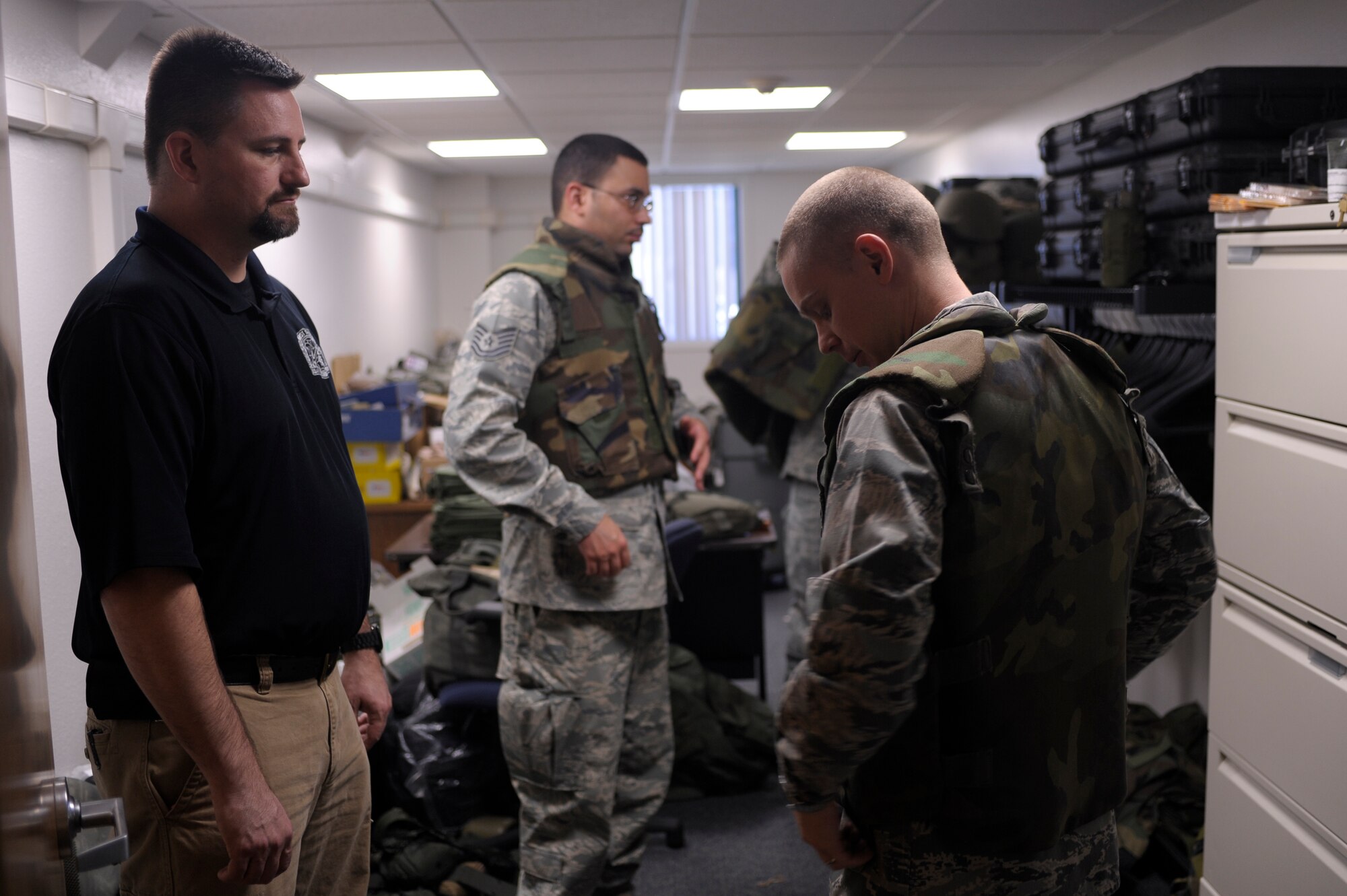 VANDENBERG AIR FORCE BASE, Calif. -- Matthew Hansen, 30th Comptroller Squadron and Wing Staff Agency unit deployment manager, assists Capt. Nick Tesmer, 30th Space Wing Judge Advocate member, with his flak jacket during a Northstar exercise bag drag here Thursday, March 8, 2012. A mobility bag consists of items essential for a deployer to have when tasked to deploy at a moments notice. (U.S. Air Force photo/Staff Sgt. Andrew Satran) 

 