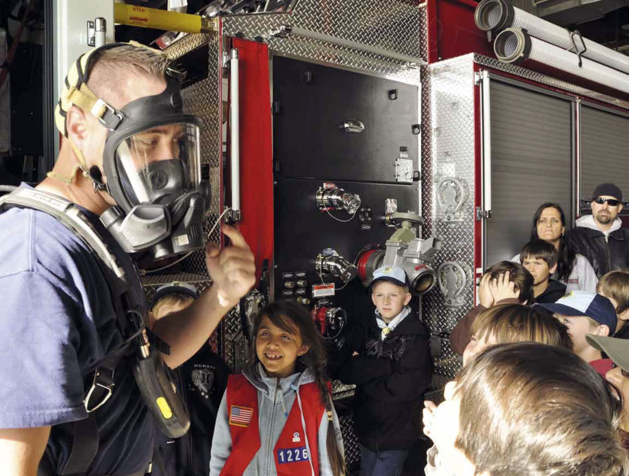 March Firefighter Philip Quinn, demonstrates the use of an air pack for children and adults from Cub Scout Pack #77, Corona, Calif., during a tour of the base March 11. The group also visited a C-17 static display and the 452d Security Forces Squadron for a weapons demonstration. (U.S. Air Force photo by Linda Welz)

