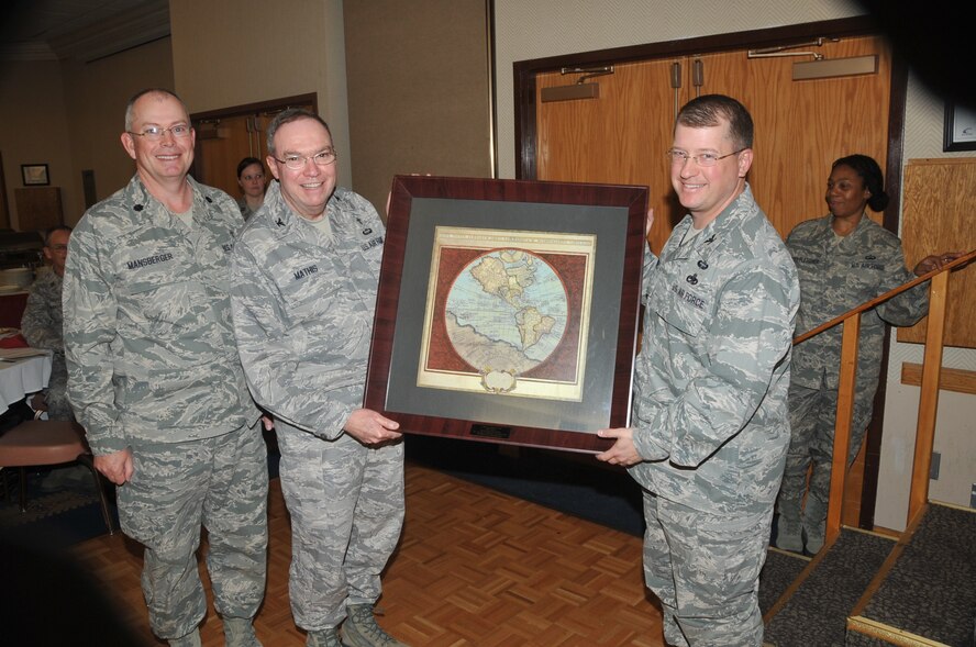 Chaplain (Lt. Col.) David Mansberger, 377th Air Base Wing Chaplain, left, and 377th Air Base Wing commander John. C. Kubinec, right, present Air Force Materiel Command Chaplain Col. Harry Mathis, center, with an Old World map of the Americas on March 9 during the National Prayer Breakfast at the Mountain View Club.

Photo by Todd Berenger
