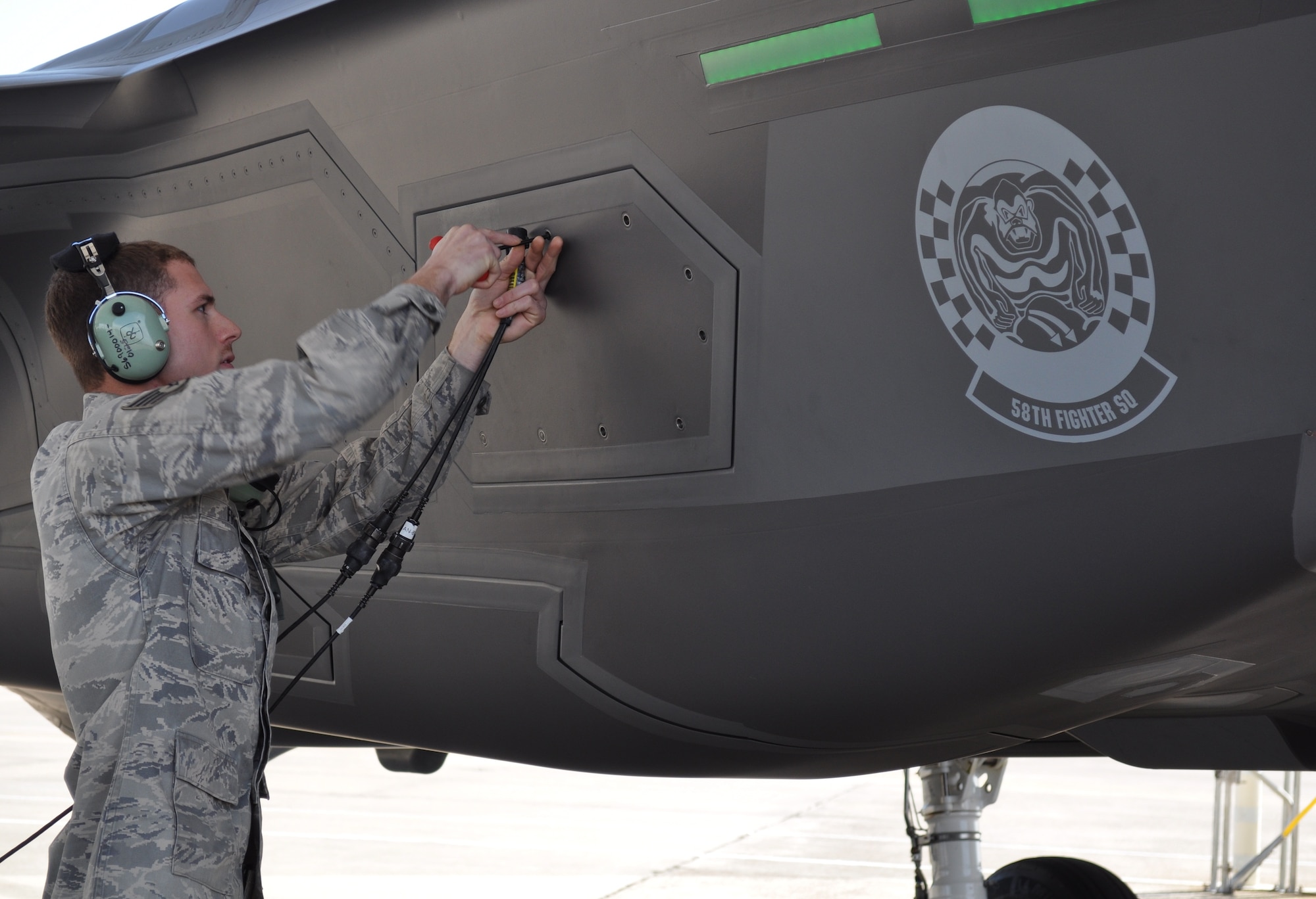 EGLIN AIR FORCE BASE, Fla. -- Staff Sgt. Andrew Fries, 33rd Aircraft Maintenance Squadron, Eglin Air Force Base, Fla., opens the maintenance interface panel so he can connect his communication cord and headset to the aircraft to establish communication with the pilot as part of the return inspection after an F-35A sortie March 13. The F-35 completed about an hour and a half orientation and was the second sortie to date. Although the first F-35 launch March 7 was successful, it was cut short after 20 minutes because of a fluid leak. The F-35 Integrated Training Center at Eglin Air Force Base has an initial goal of two sorties a week, and plans to steadily increase. (U.S. Air Force photo/Maj. Karen Roganov)