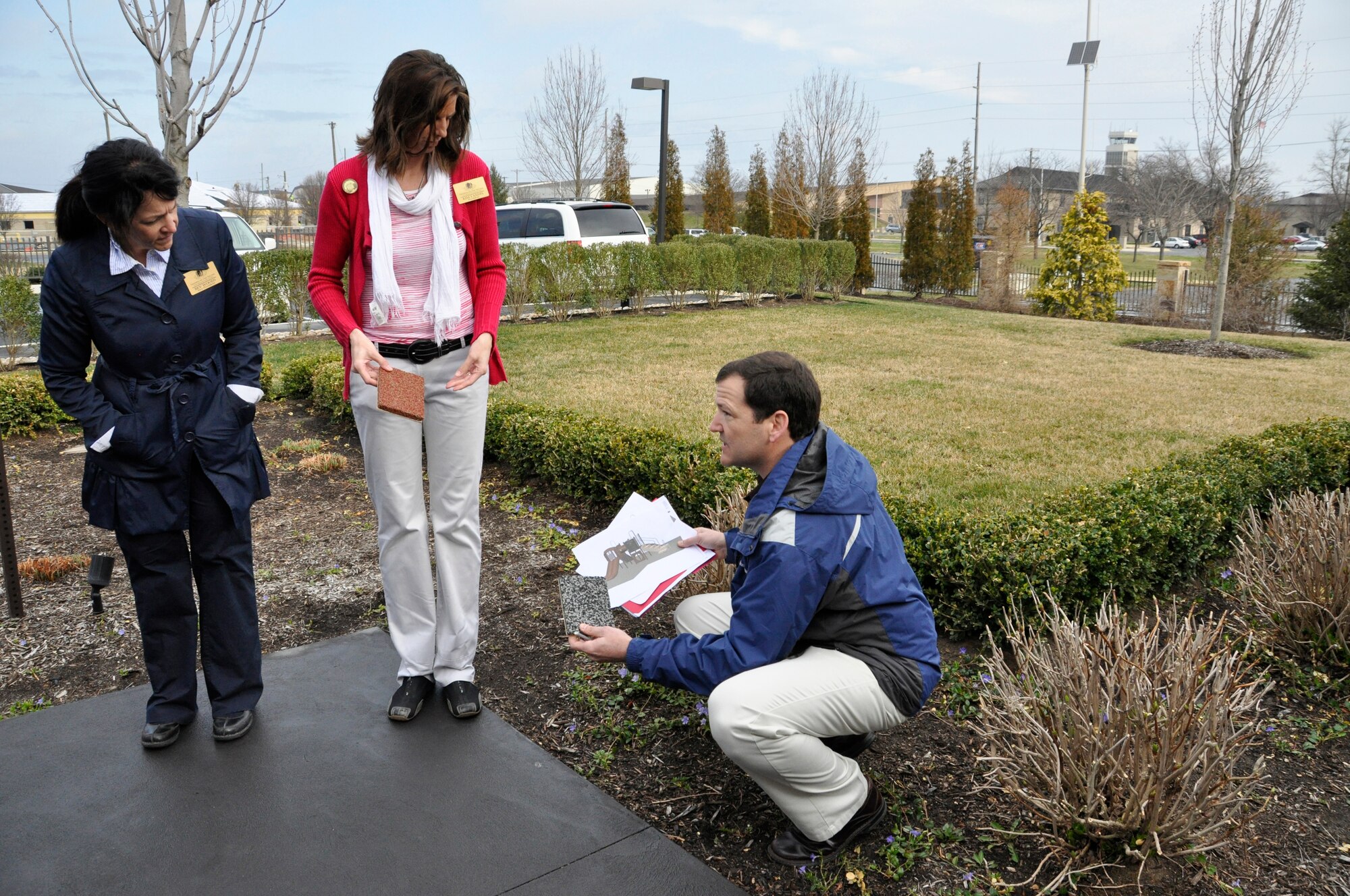 Charlie Walker, an equipment manufacturer representative, shows Kim Landis (right) and Bev Woods, Friends of the Fallen president and vice president, rubberized surface color choices March 13, 2012. The rubberized surface will accompany a new playground to be built outside the Fisher House for Families of the Fallen, Dover Air Force Base, Del., by summer. (U.S. Air Force photo/Master Sgt. Veronica Aceveda)