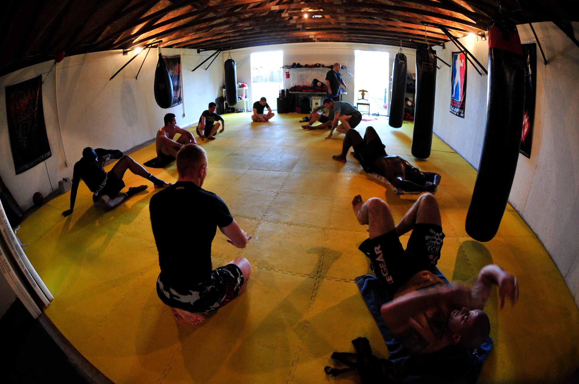 U.S. Air Force Staff Sgt. Ferdinando Acerra (bottom right), a maintenance training instructor assigned to the 20th Medical Operations Squadron, 20th Fighter Wing, Shaw Air Force Base, S.C. performs stretches alongside his mix martial arts peers while at the Sor Sumrit Muay Thai Gym in Columbia, S.C. on March 13, 2012. Acerra, along with two others from his gym will compete in matches at Shaw AFB's first ever MMA event on March 30, 2012. (U.S.  Air Force photo/Master Sgt. Cohen A. Young/Released)