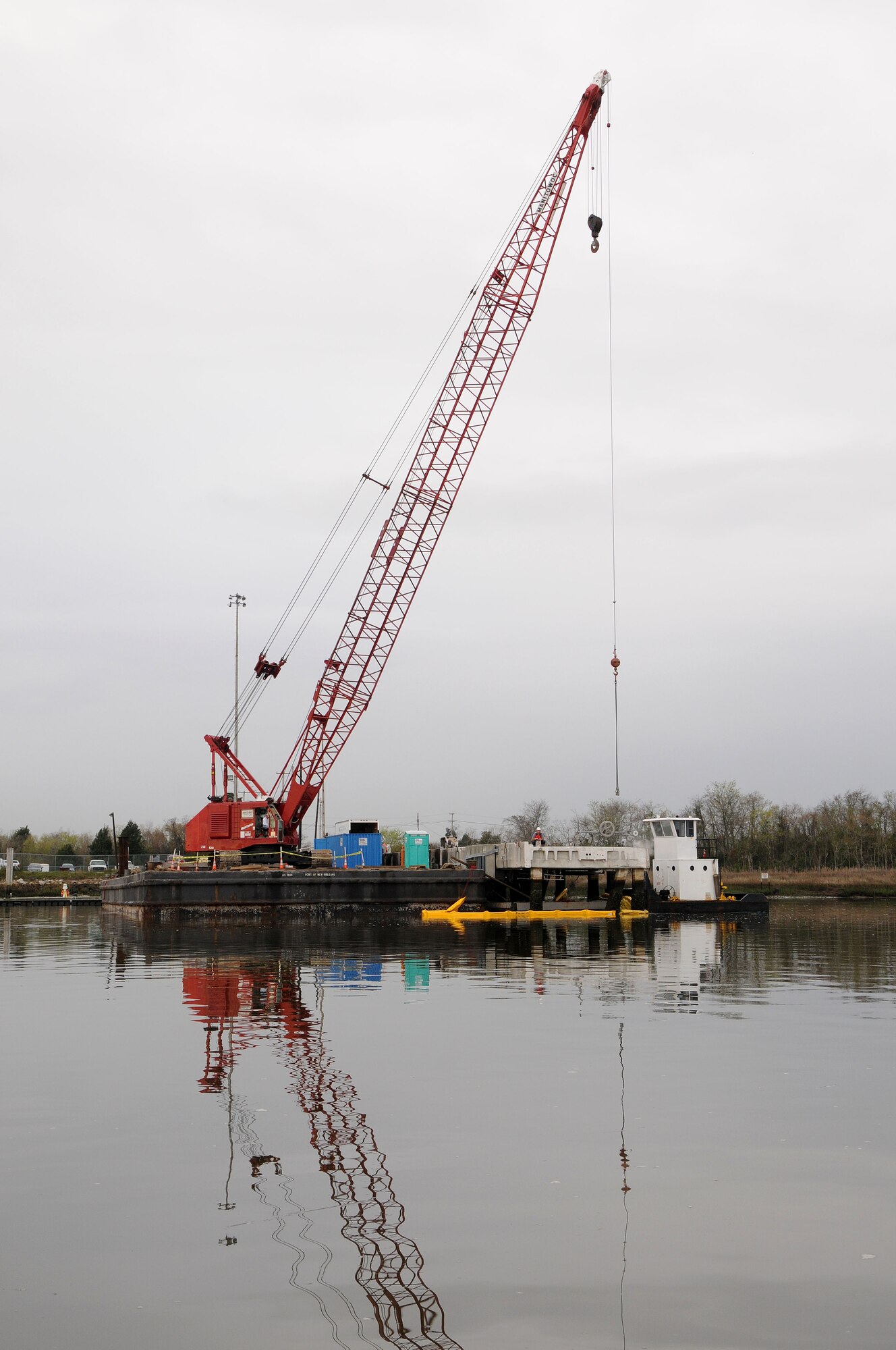 Contractors work at cutting and preparing section of Pier Charlie to be lifted by crane at Joint Base Charleston-Weapons Station, March 13. Pier Charlie is being demolished as part of a program to remove excess infrastructures. Once Pier Charlie is dismantled, workers will build a smaller pier to allow Harbor Patrol Units access to the 628th Logistics Readiness Squadron Port Operations Facility.  (U.S. Navy photo/Petty Officer 1st Class Jennifer Hudson)