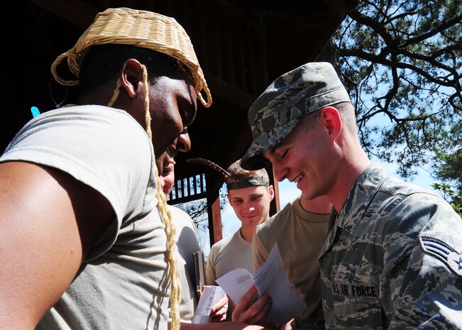 Senior Airmen Ronald Sangston and Derrick Whitaker participate in the Nwoknu tribe exercise at Joint Base Charleston - Air Base Mar. 2. The exercise demonstrates the importance of effective communication and possible communication barriers that relate to global diversity and regional awareness that can occur while on a deployment. Sangston is a 437th Maintenance Squadron hydraulic systems journeyman, 437th Airlift Wing and Whitaker is a 628th force Support Squadron food services specialist. (U.S. Air Force photo/Staff Sgt. Katie Gieratz) 
