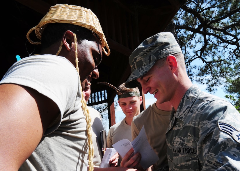 Senior Airmen Ronald Sangston and Derrick Whitaker participate in the Nwoknu tribe exercise at Joint Base Charleston - Air Base Mar. 2. The exercise demonstrates the importance of effective communication and possible communication barriers that relate to global diversity and regional awareness that can occur while on a deployment. Sangston is a 437th Maintenance Squadron hydraulic systems journeyman, 437th Airlift Wing and Whitaker is a 628th force Support Squadron food services specialist. (U.S. Air Force photo/Staff Sgt. Katie Gieratz) 
