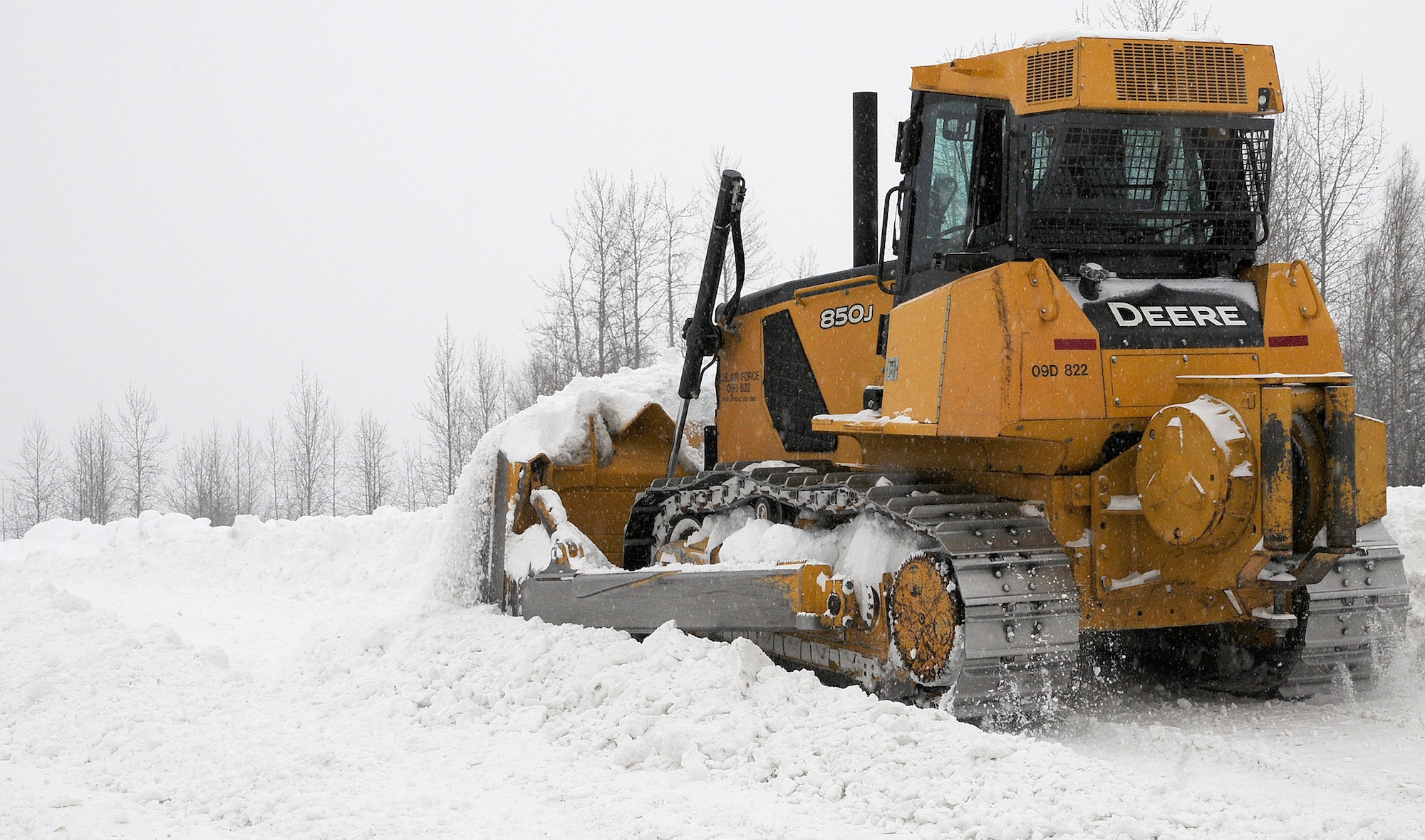 An Eielson bulldozer clears an area at a snow removal site in order for more snow to be transported and dumped March 9, 2012, Eielson Air Force Base, Alaska. The snow removal team works daily in 8-hour rotating shifts, constantly clearing and transporting snow on base. (U.S. Air Force photo/Airman 1st Class Zachary Perras)