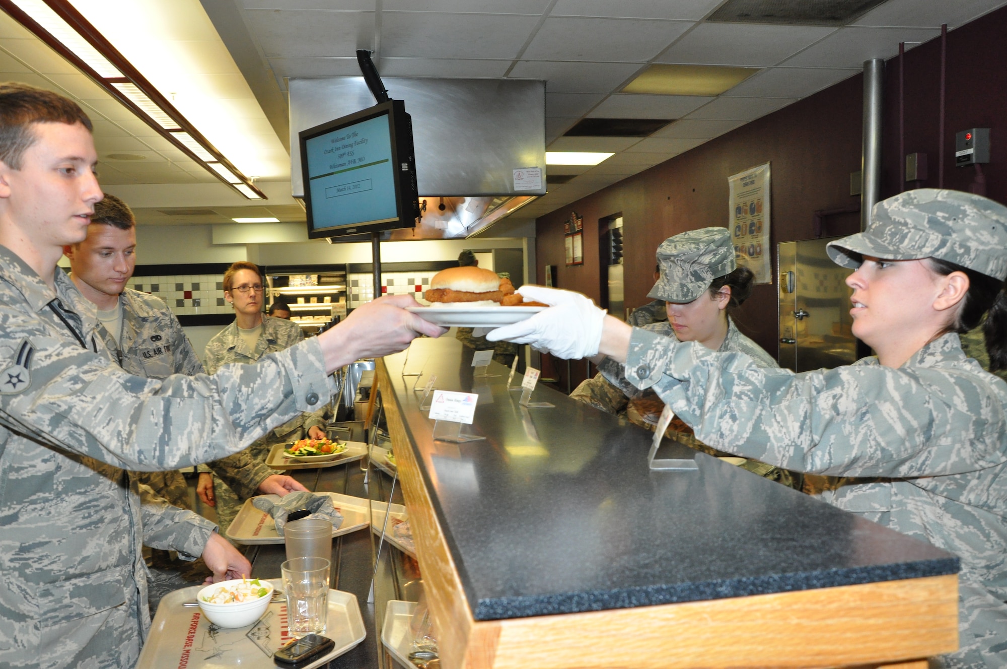 Airman Martina Kellums, 442nd Force Support Squadron, serves a meal to an Airman at the Ozark Inn dining facility on March 14, 2012. Kellums was selected through the Culinary Excellence Program to attend a one-week course at the Culinary Institute of America at Napa Valley, Calif. The 442nd FSS is part of the 442nd Fighter Wing, an A-10 Thunderbolt II Air Force Reserve unit at Whiteman Air Force Base, Mo. (U.S. Air Force Photo/Senior Airman Wesley Wright)