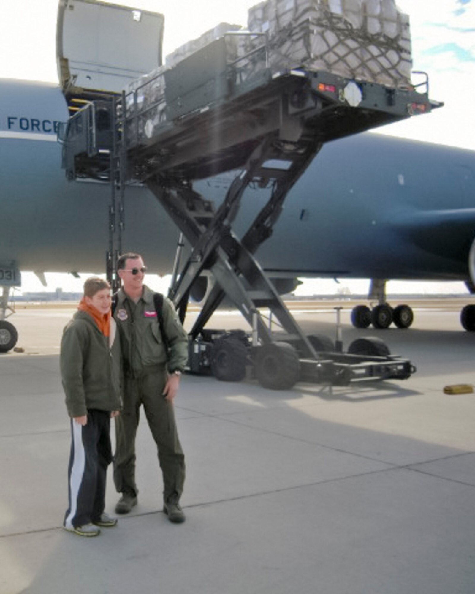 Christian Sanders of Marshall, Minnesota, poses with pilot, 1st Lt. Jason Van Parys, while pallets of supplies are loaded into a KC-10 at the Minneapolis-St. Paul Air Reserve Station, MN.  Christian collected more than 1,000 pairs of shoes for donation. The Denton Program allows donors to put humanitarian supplies aboard U.S. military transport on a space-available basis.  (Courtesy Photo)

