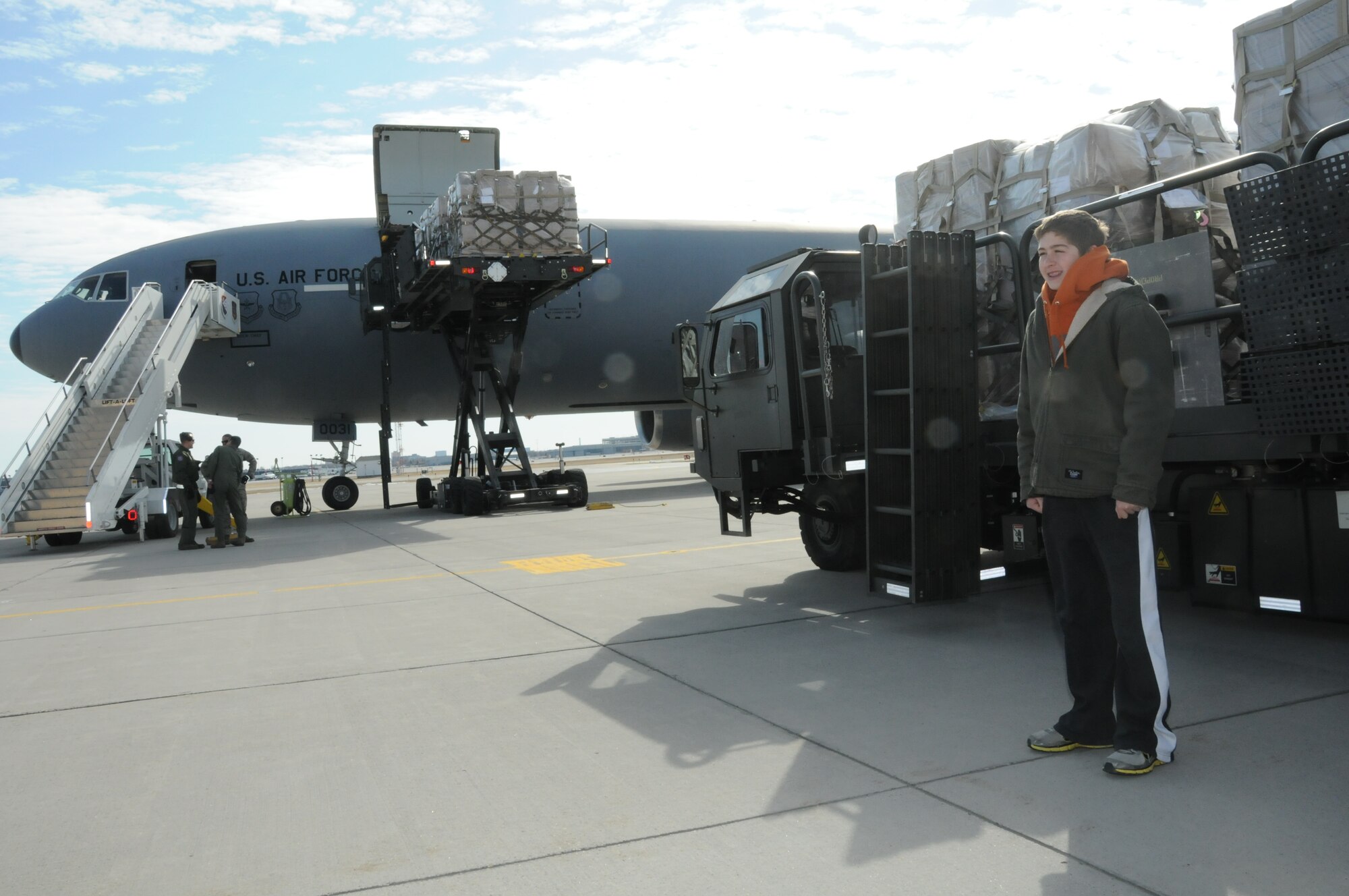 Christian Sanders of Marshall, Minnesota, stands in front of pallets of supplies waiting to be loaded into a KC-10 at the Minneapolis-St. Paul Air Reserve Station, MN.  He collected more than 1,000 pairs of shoes for donation. The Denton Program allows donors to put humanitarian supplies aboard U.S. military transport on a space-available basis.  (U.S. Air Force Photo/Paul Zadach)

