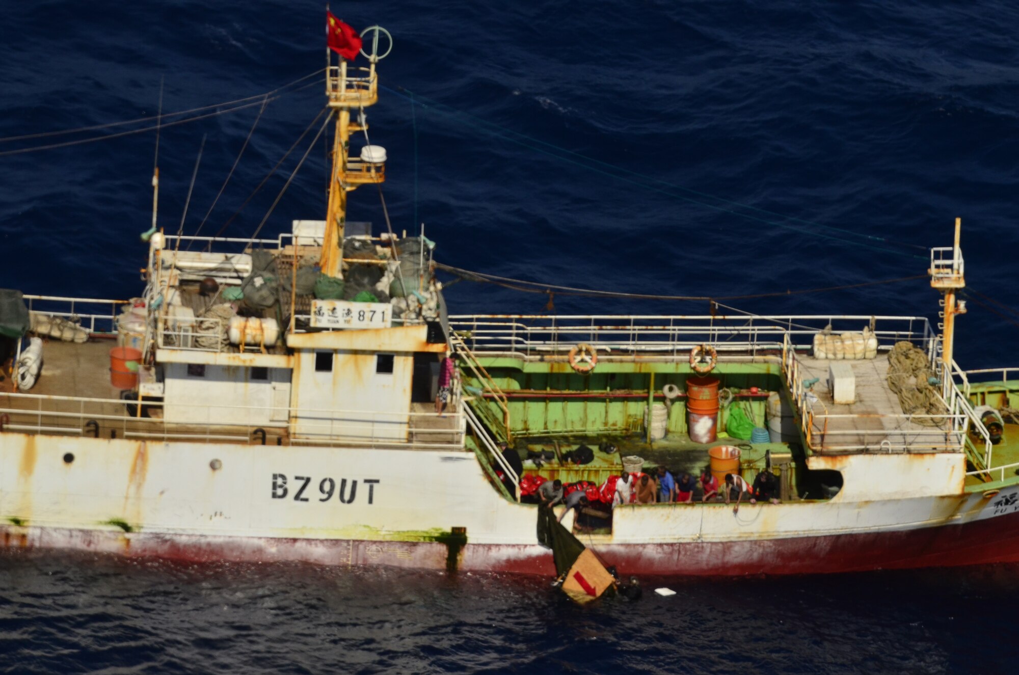 Crews on board the Chinese fishing vessel Fu Yuan Yu #871 assist Guardian Angel Pararescuemen from the 129th Rescue Wing. PJs were there to provide medical treatment to injured fisherman on the vessel March 11, 2012. Airmen from the wing conducted a long-range over-water rescue mission 700 miles off the coast of Acapulco, Mexico to rescue the two fishermen who were burned in a diesel fire days prior. (Air National Guard photo by Airman 1st Class John Pharr)