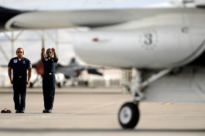 Staff Sgt. Tacota LeMuel, Thunderbird 3 dedicated crew chief and Staff Sgt. John Mantanona, Thunderbird 8 assistant dedicated crew chief, marshals in Maj. Caroline Jensen, Thunderbird 3, Right Wing pilot, after returning from a training sortie at Nellis Air Force Base, Nev., March 12, 2012.
(U.S. Air Force photo/Staff Sgt. Larry E. Reid Jr., Released)