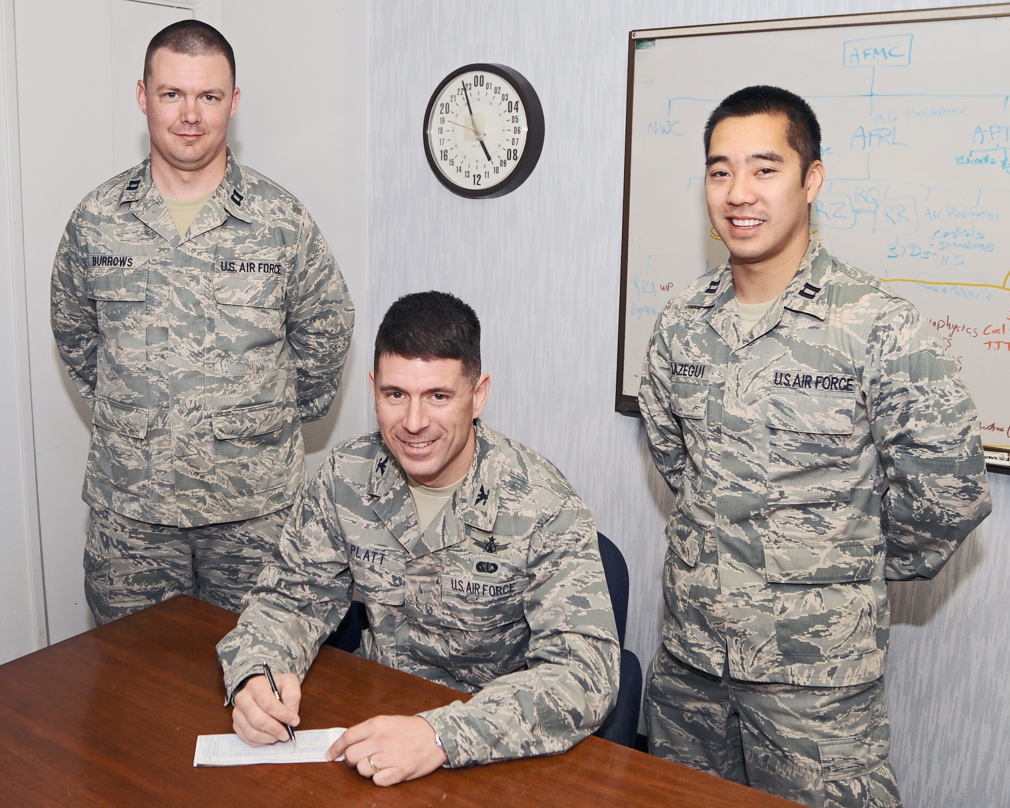 With the help of Air Force Aassistance Fund campaign installation project officers, Col. Michael Platt, Air Force Research Laboratory commander, prepares to sign his payroll deduction form March 7 in support of the annual campaign. The AFAF was established to provide for an annual effort to raise funds for the charitable affiliates that provide support to the Air Force family (active duty, retirees, reservists, guard and their dependents, including surviving spouses) in need. (U.S. Air Force photo by Ron Fair)