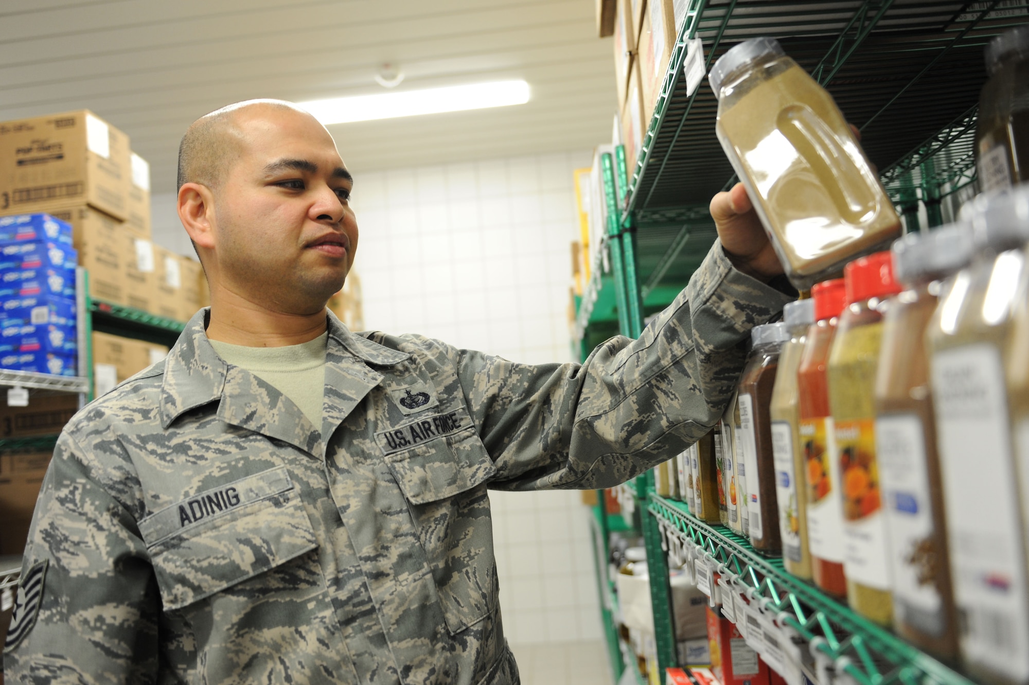 SPANGDAHLEM AIR BASE, Germany – Tech. Sgt. Andrews Adinig, 52nd Force Support Squadron dining facility assistant manager, restocks shelves after a food product delivery at the Mosel Hall Dining Facility here March 13. The DFAC provides fresh meals to more than 4,270 enlisted service members on a daily basis to include breakfast, lunch, dinner and midnight meals. In addition, they provide service to all Department of Defense civilians, military service members and reserve officer training corps cadets with temporary duty orders. The DFAC also provides service to all family members and retirees on a case by case base, such as Thanksgiving, Christmas and Air Force birthdays. (U.S. Air Force photo by Senior Airman Christopher Toon/Released)