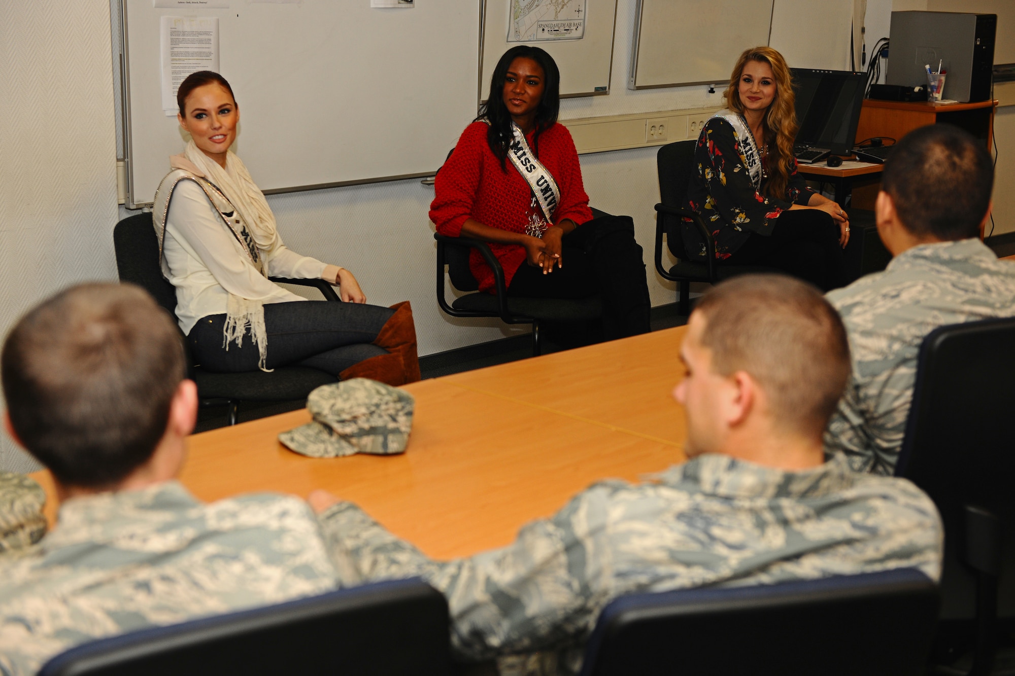 SPANGDAHLEM AIR BASE, Germany – Alyssa Campanella, Miss USA 2011, left; Leila Lopez, Miss Universe 2011, middle; and Danielle Doty, Miss Teen USA 2011, talk with Airman at the First Term Airmen’s Center classroom during their USO and Armed Forces Entertainment tour here March 13. The purpose of the tour was to boost morale and show support to U.S. service members and their families stationed in Germany. (U.S. Air Force photo by Airman 1st Class Matthew B. Fredericks/Released)