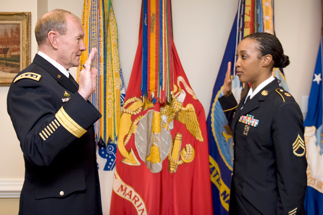 Staff Sgt. Patricia Conyers, United States Army Training and Doctrine Command Band vocalist, is re-enlisted by General Martin E. Dempsey, Chairman, Joint Chiefs of Staff, in his office at the Pentagon Mar. 7, 2012. Demspey and Conyers worked together at TRADOC when Dempsey was assigned there. (U.S. Army photo by Staff Sgt. Sun Vega/Released)