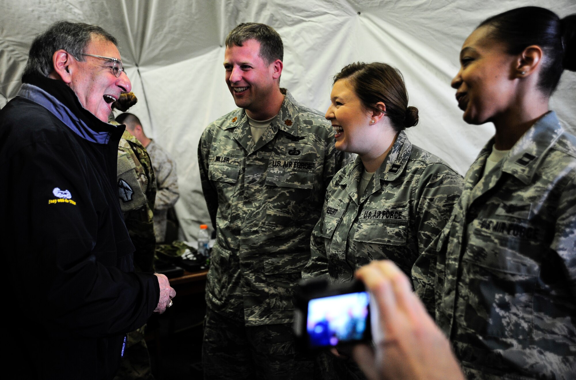 Secretary of Defense Leon Panetta shares a laugh with Maj. Brian Miller, Capt. Holly Gebert and Capt. Kay Stern March 14, 2012, during a visit to the Transit Center at Manas, Kyrgyzstan. The Airmen are deployed to the Transit Center's Theater Security Cooperation division. Miller is deployed from the Pentagon, Gebert is deployed from Wright-Patterson Air Force Base, Ohio, and Stern is deployed from Kirtland AFB, N.M. (U.S. Air Force photo/Staff Sgt. Angela Ruiz)