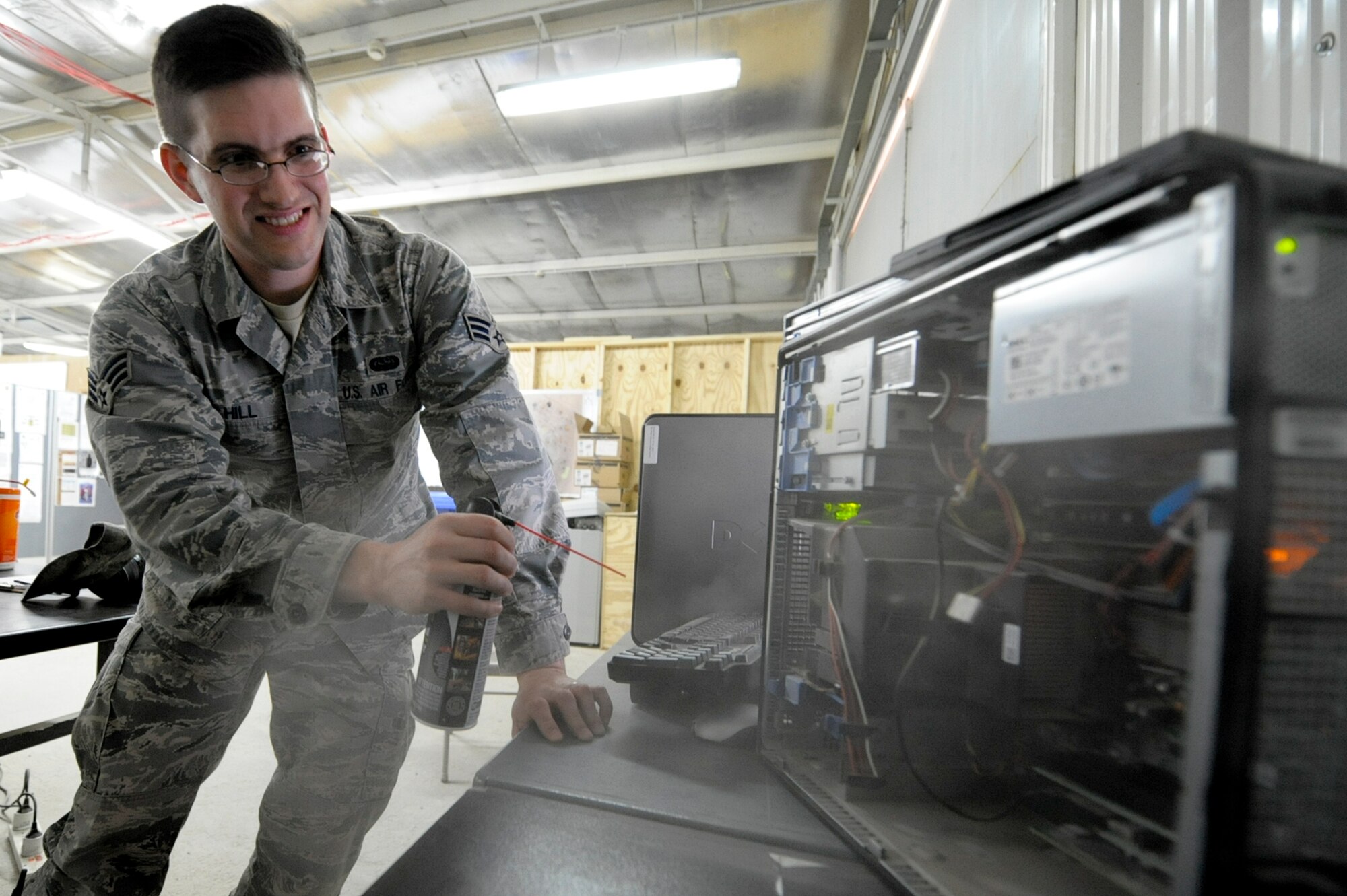 Senior Airman Cody Hill, 332nd Expeditionary Communication Squadron operations flight member, uses canned air to clean the inside of a desktop computer at an undisclosed location in Southwest Asia, March 12, 2012. Dust buildup can cause computer fans to seize, which can lead to damage of critical components. Hill is deployed from Ramstein Air Base, Germany, and is a native of Van Alstyne, Texas. (U.S. Air Force photo by Staff Sgt. Joshua J. Garcia)