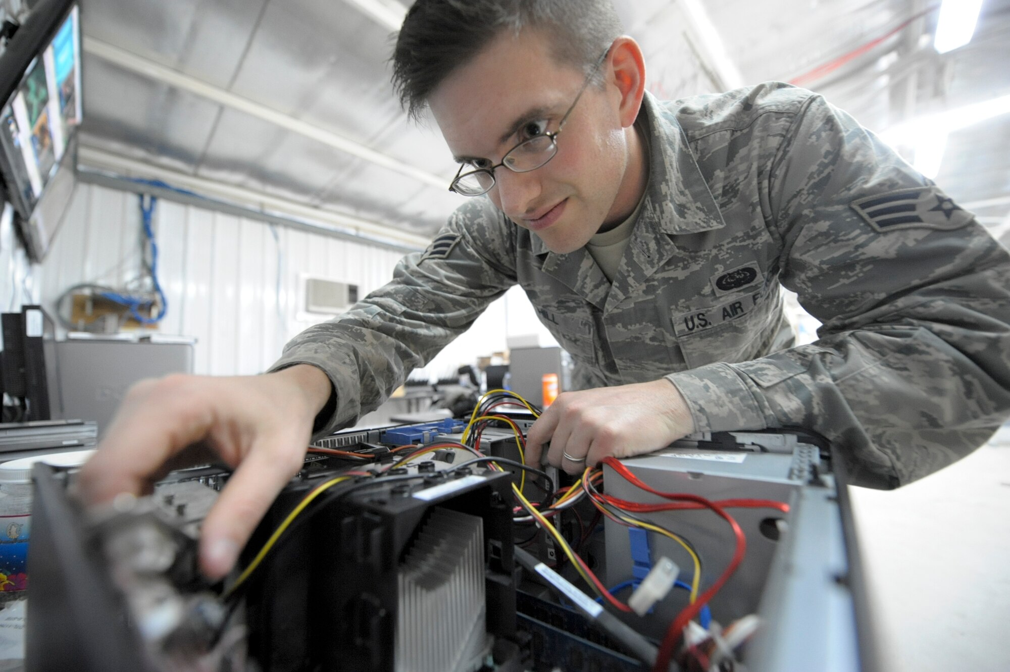 Senior Airman Cody Hill, 332nd Expeditionary Communication Squadron operations flight member, rebuilds a desktop computer at an undisclosed location in Southwest Asia, March 12, 2012. Hill disassembles desktops to locate issues with broken computers. He is deployed from Ramstein Air Base, Germany, and is a native of Van Alstyne, Texas. (U.S. Air Force photo by Staff Sgt. Joshua J. Garcia)